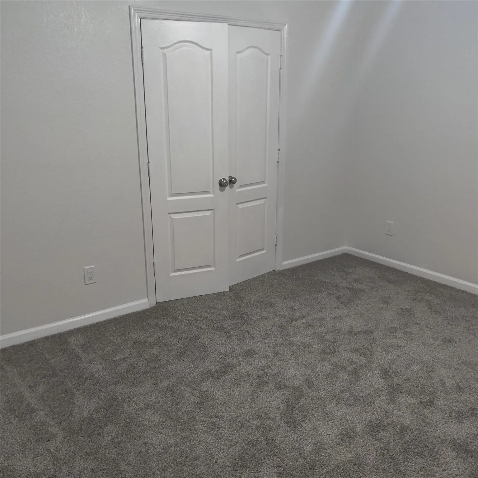 Unfurnished bedroom with dark carpet and a closet