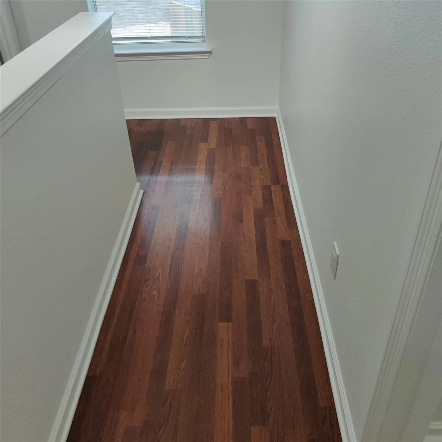 Hall featuring dark wood-style flooring and baseboards