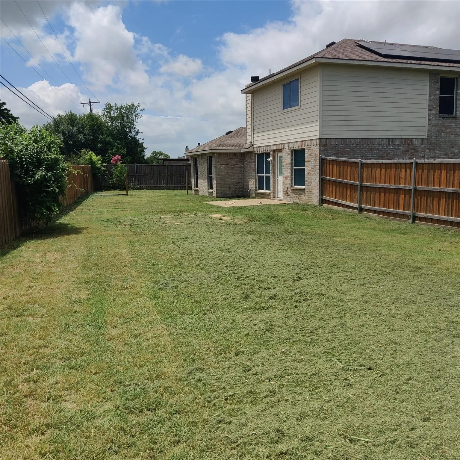 Fenced backyard with a patio