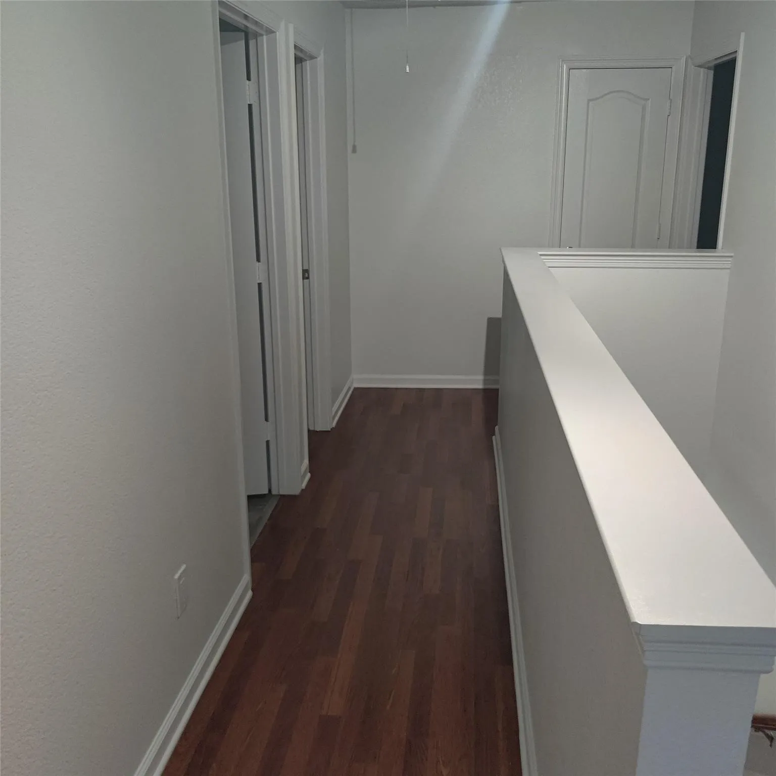 Hallway with dark wood finished floors and attic access