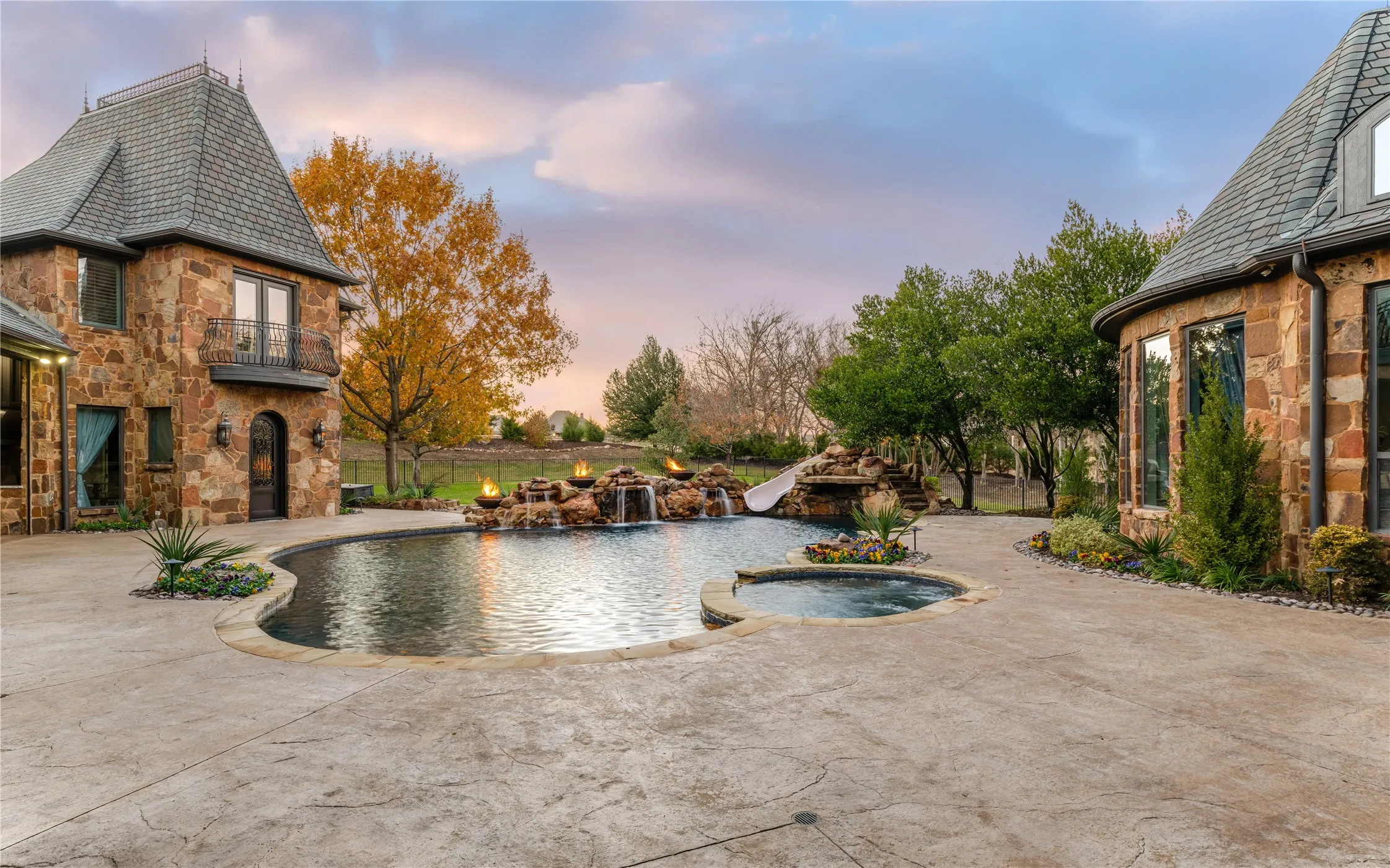 Resort backyard with pool, slide, fire bowls