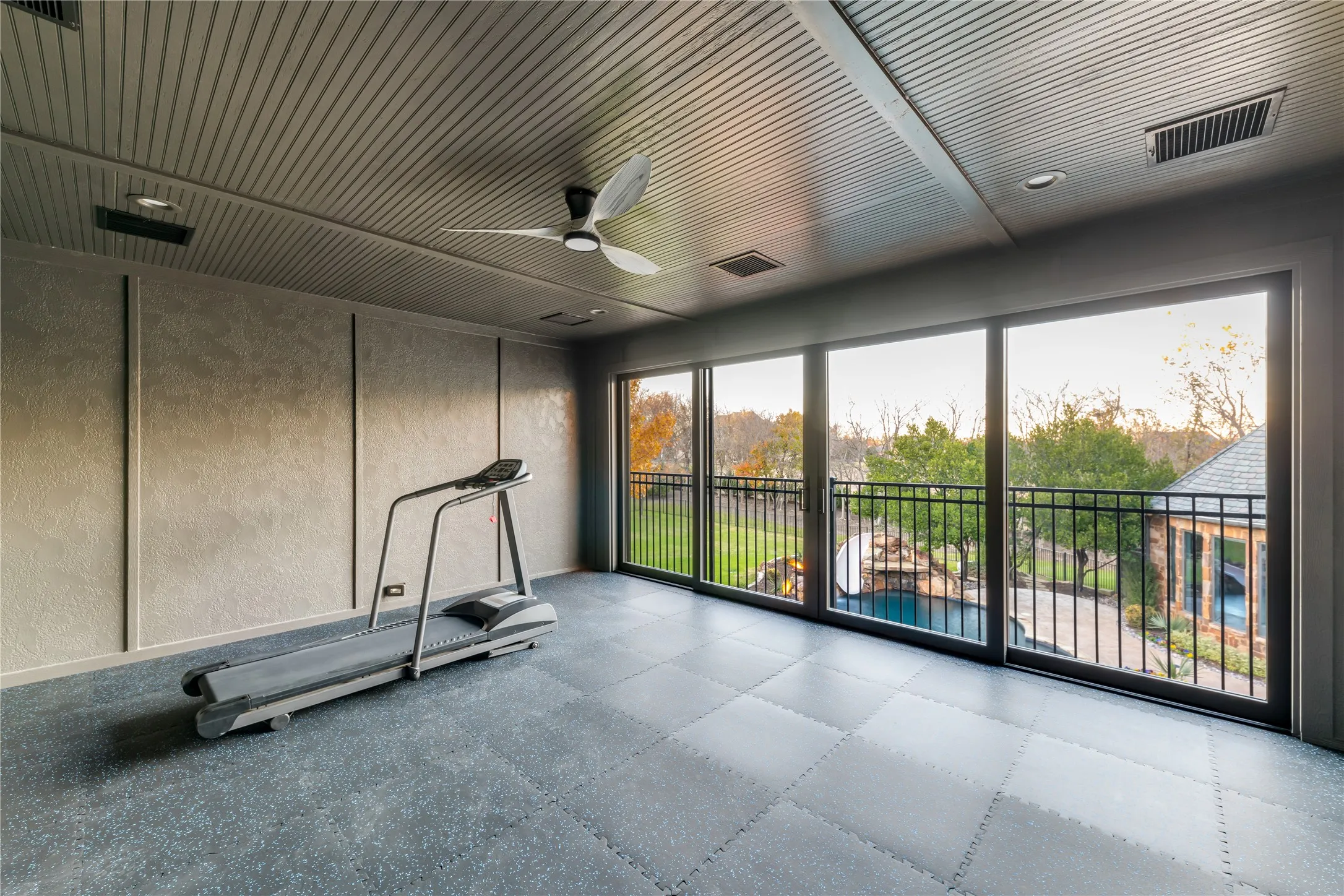 Exercise room with sliding doors that overlooks the pool