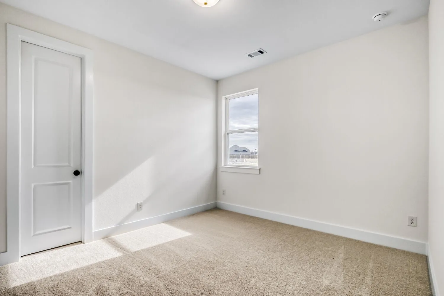 Carpeted spare room featuring baseboards