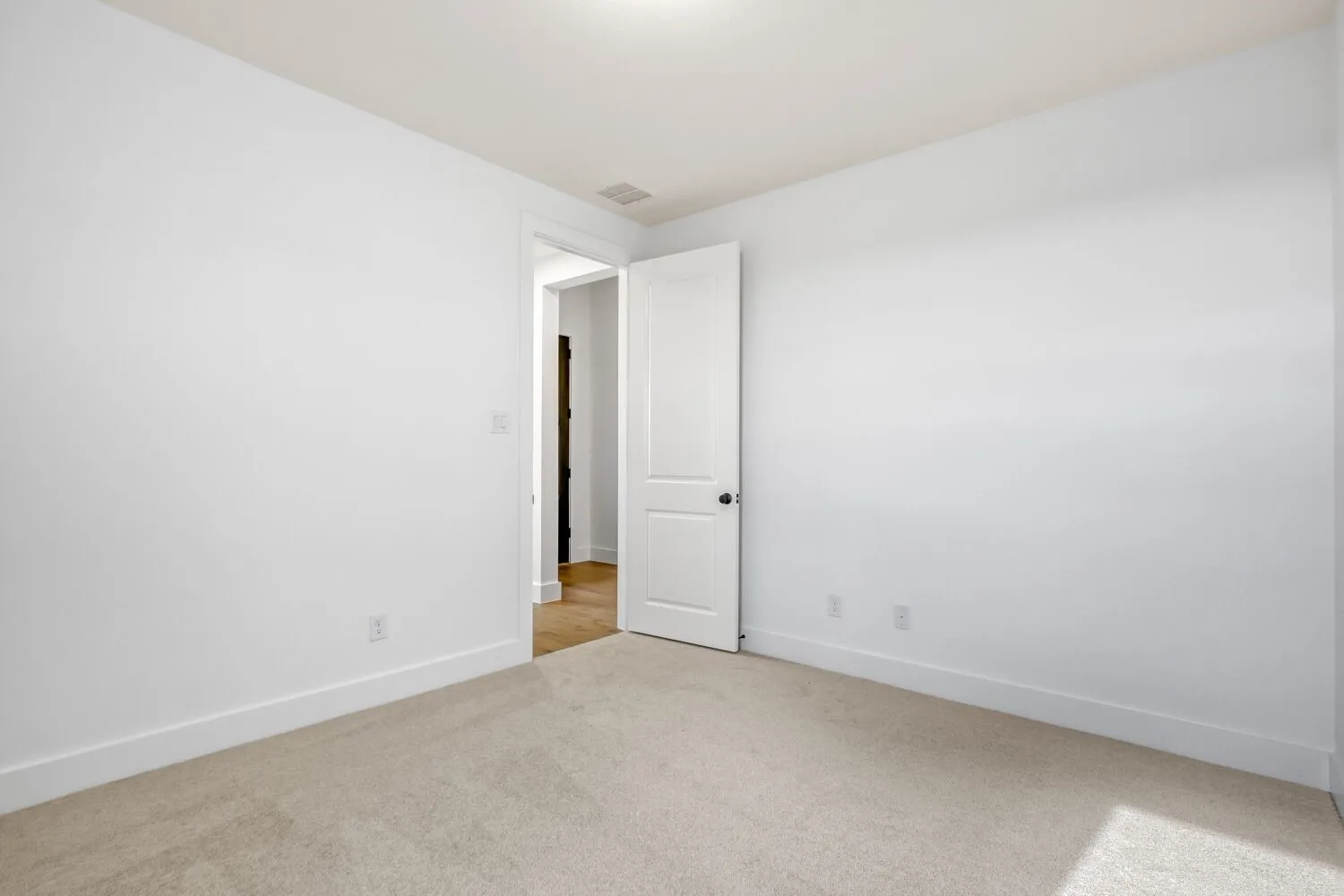 Empty room featuring light carpet and baseboards