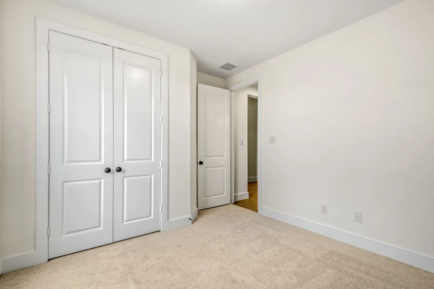Unfurnished bedroom featuring light carpet and a closet