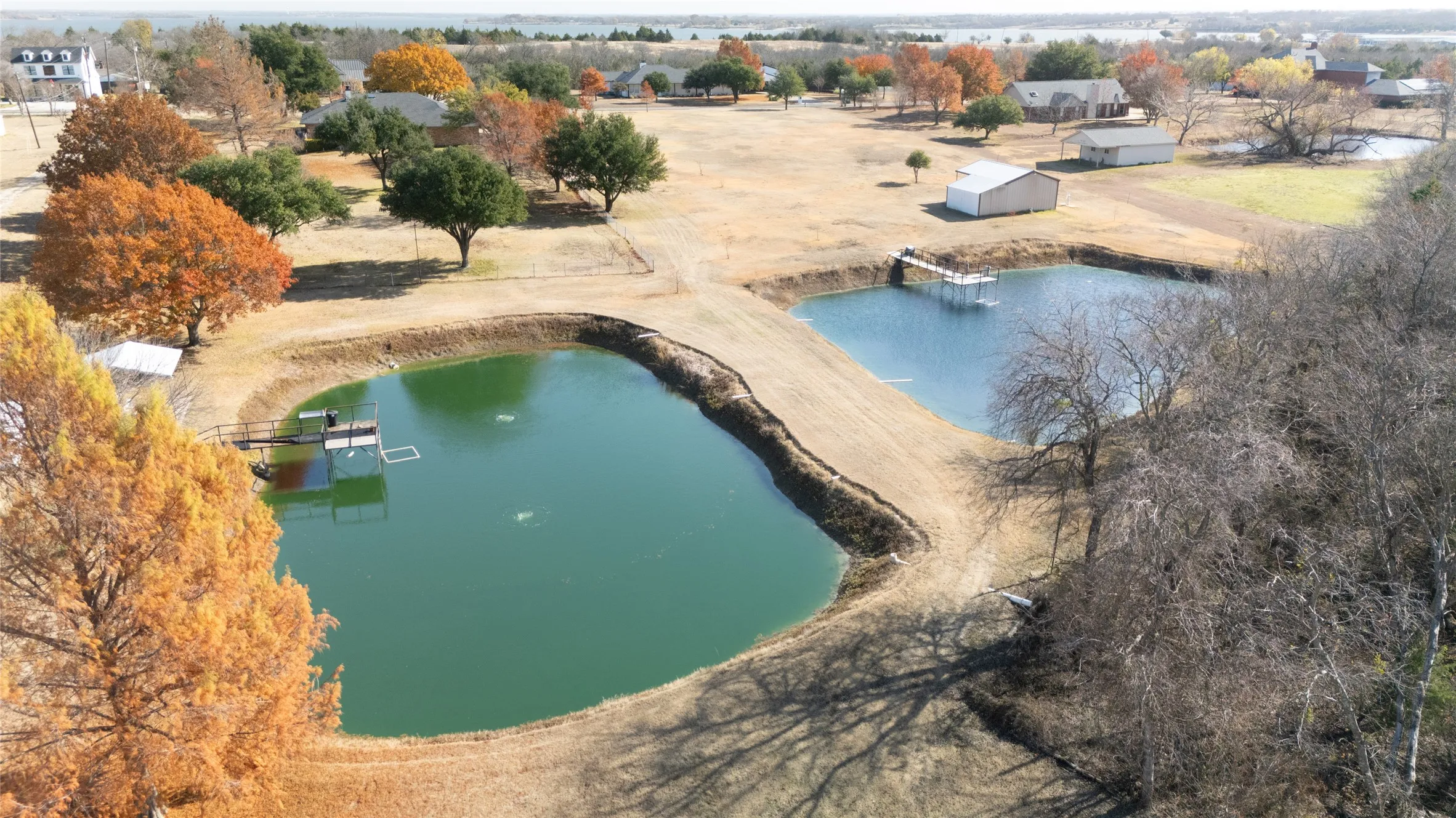 Pond in foreground, and tree-shaded lot.