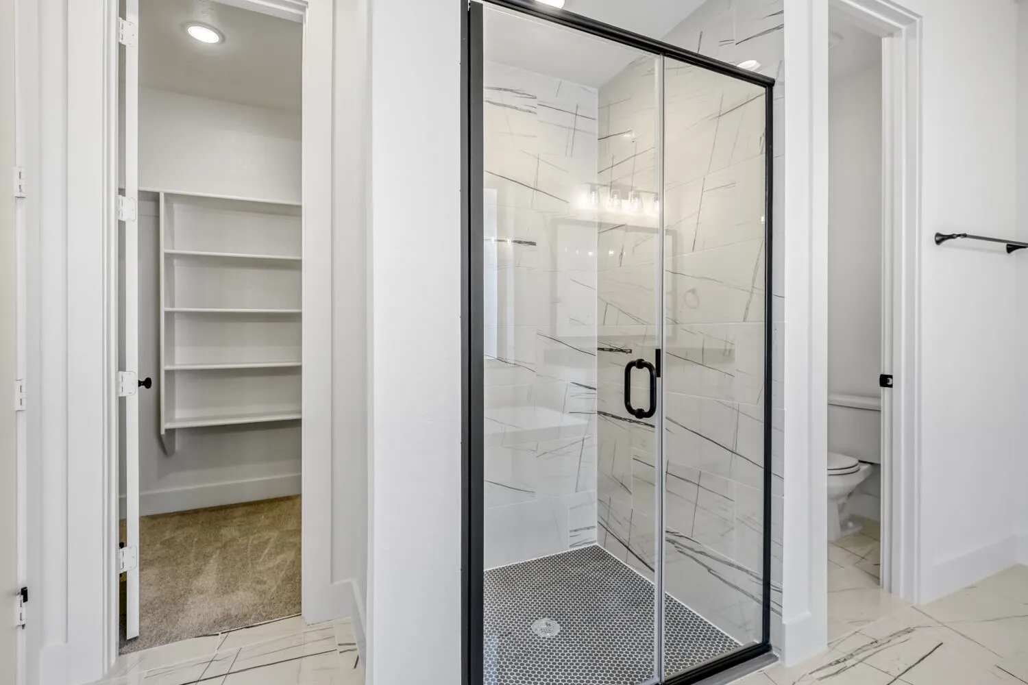 Full bath with a marble finish shower, light marble finish flooring, and a spacious closet