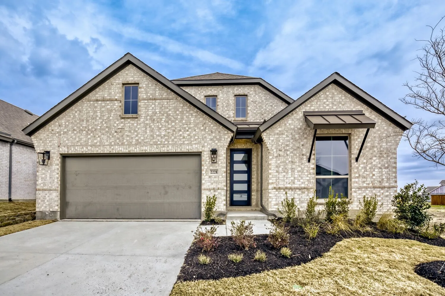 View of front facade with concrete driveway, a garage, and brick siding