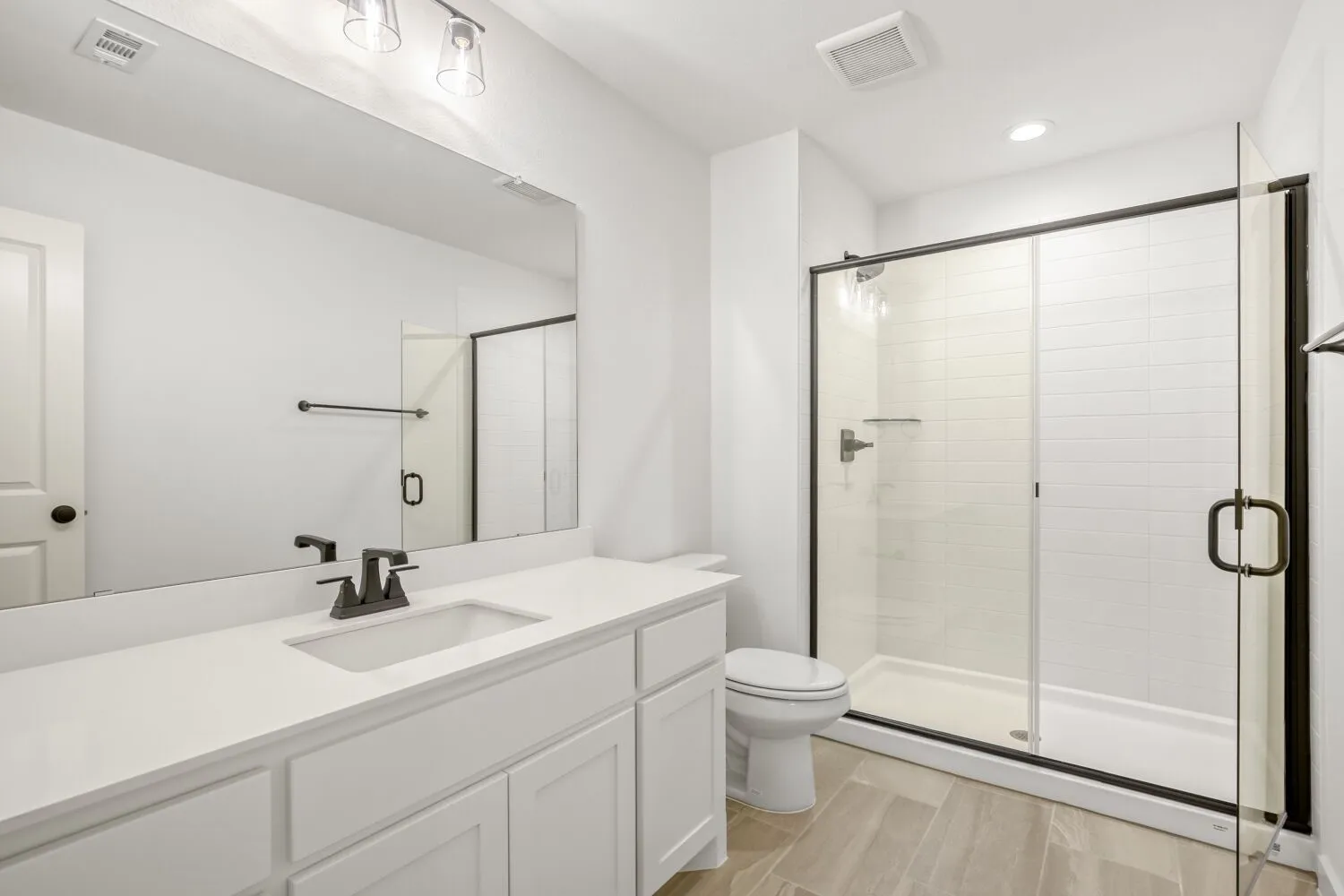 Bathroom featuring a shower stall, vanity, wood tiled floors, and recessed lighting