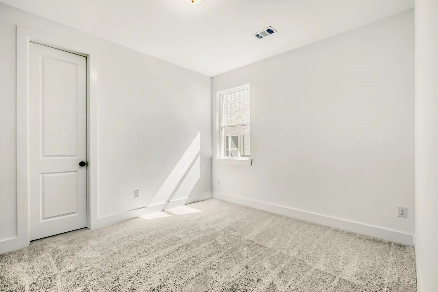 Spare room featuring light carpet and baseboards
