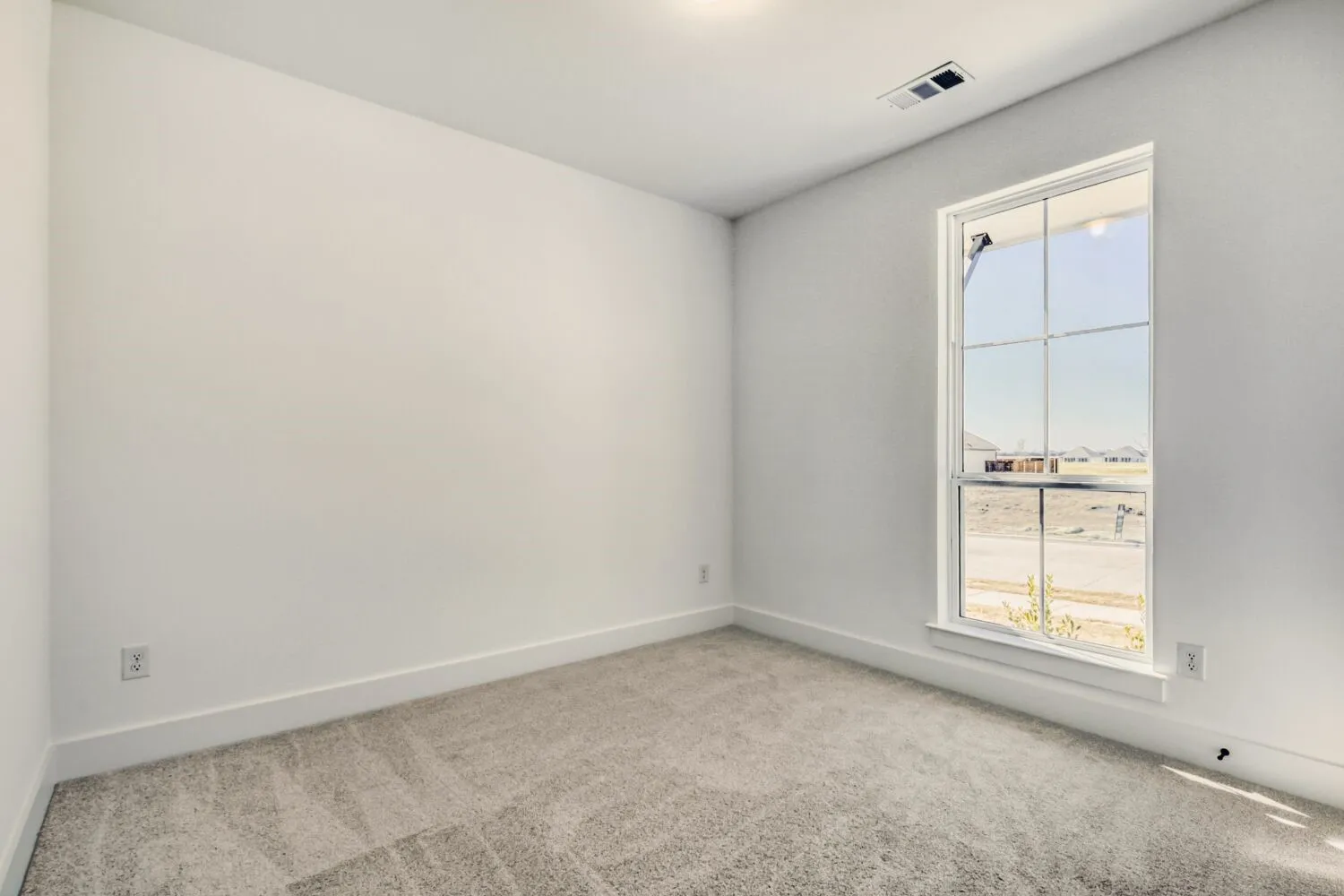 Spare room with light colored carpet and baseboards