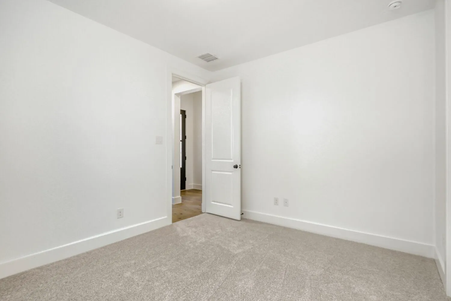 Empty room featuring light carpet and baseboards