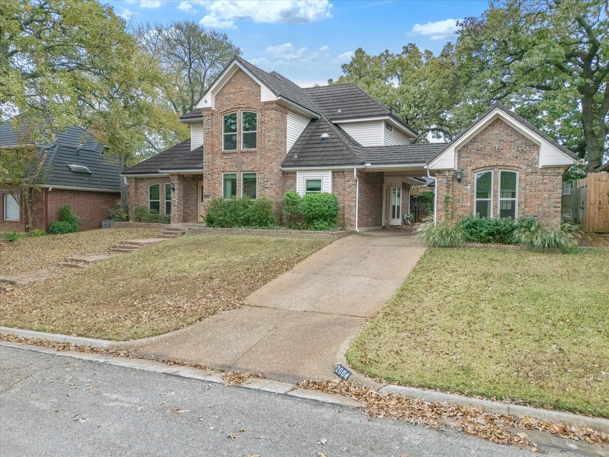 View of front facade featuring brick siding and concrete driveway