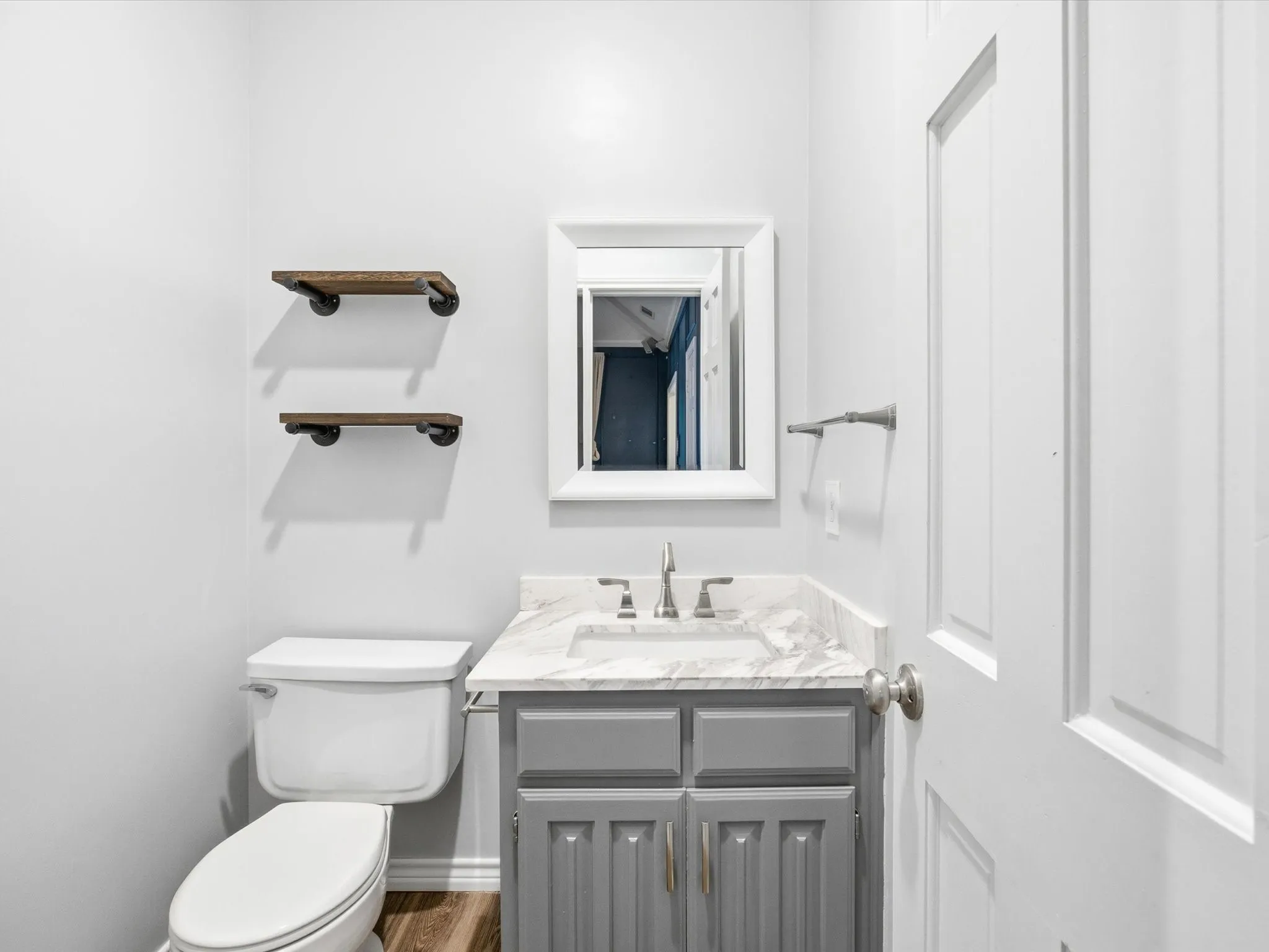 Half bathroom featuring vanity and toilet