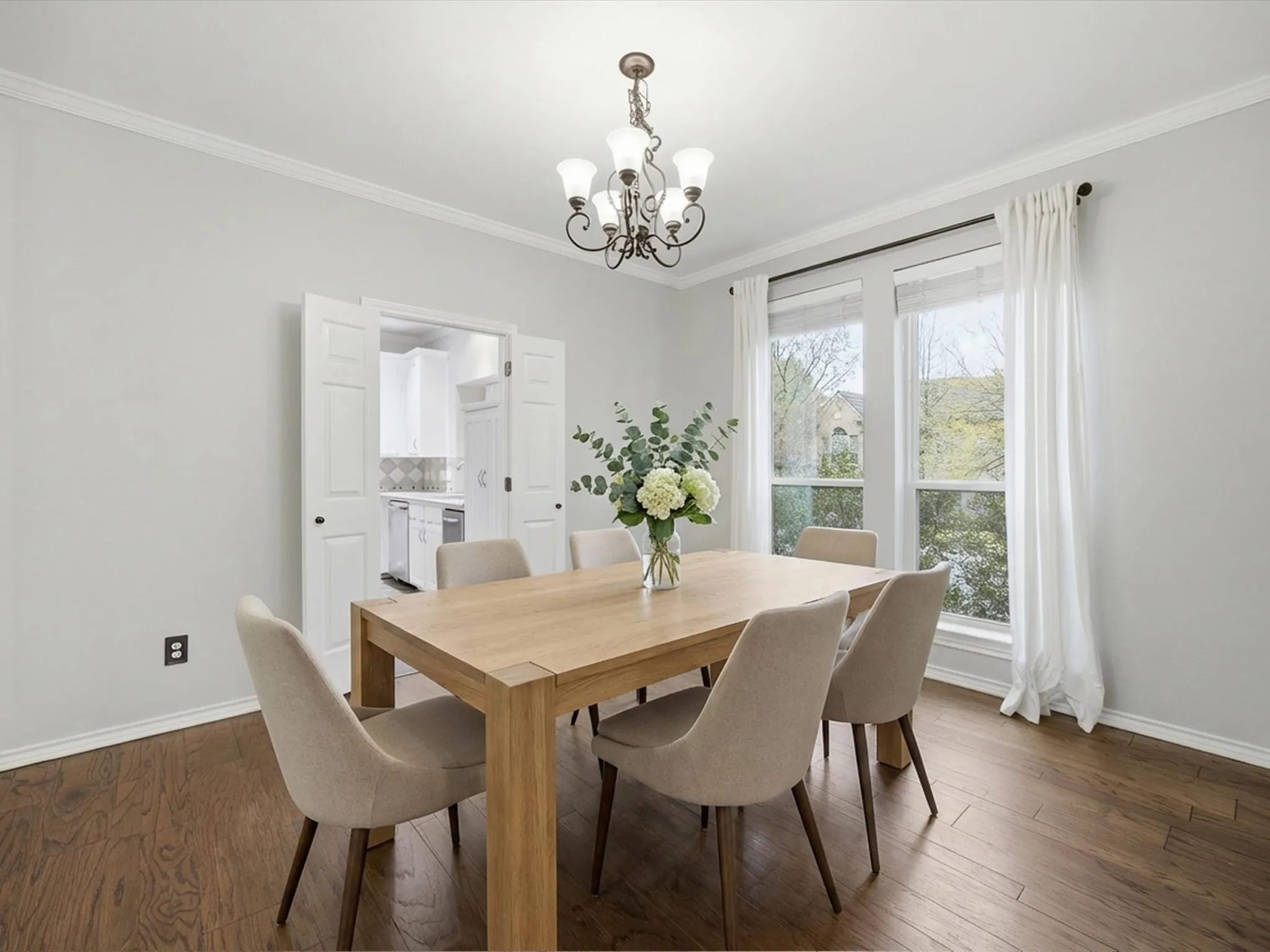 Dining room featuring dark wood-style flooring, crown molding, and a chandelier