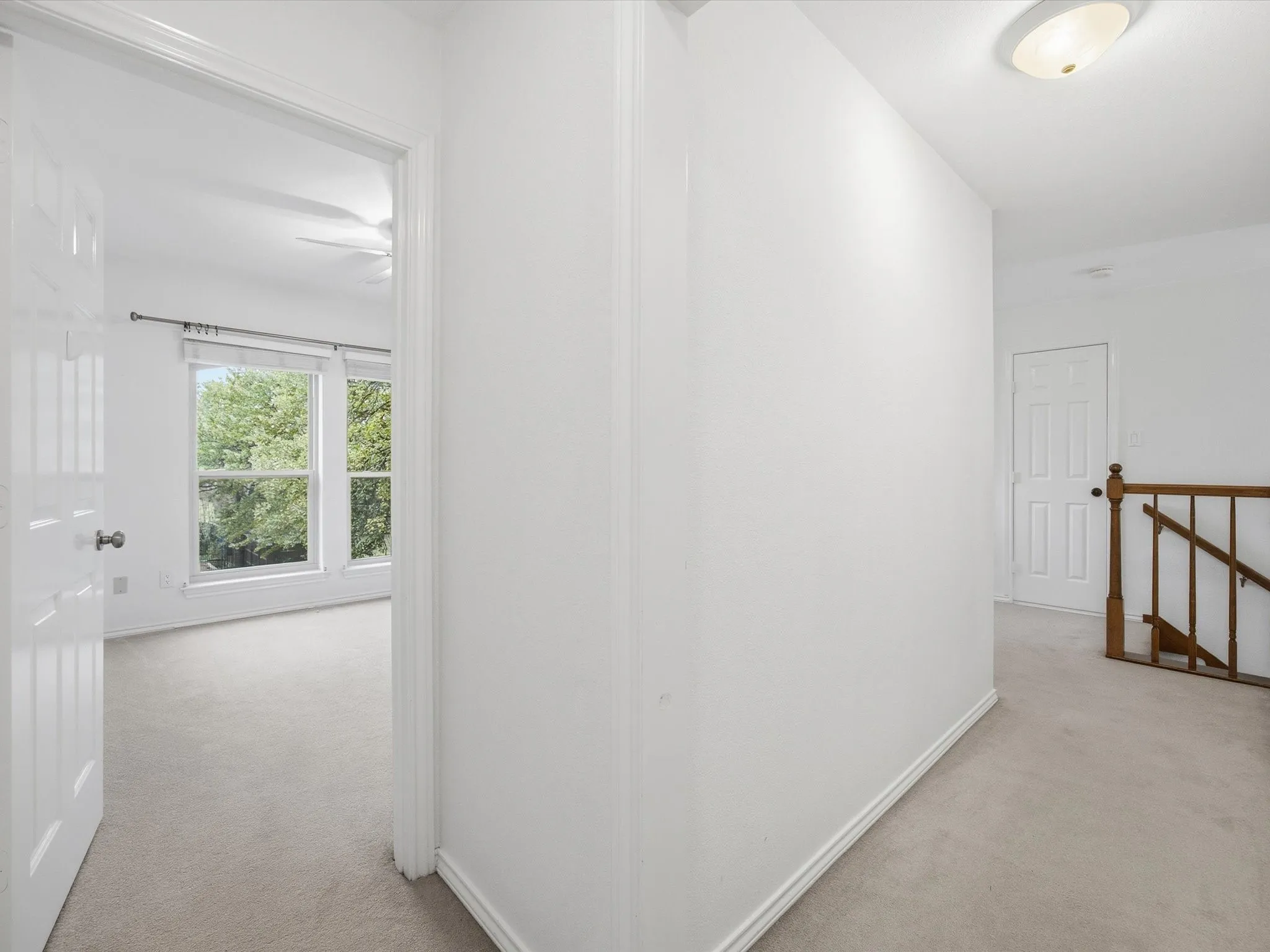 Hall with light carpet and an upstairs landing