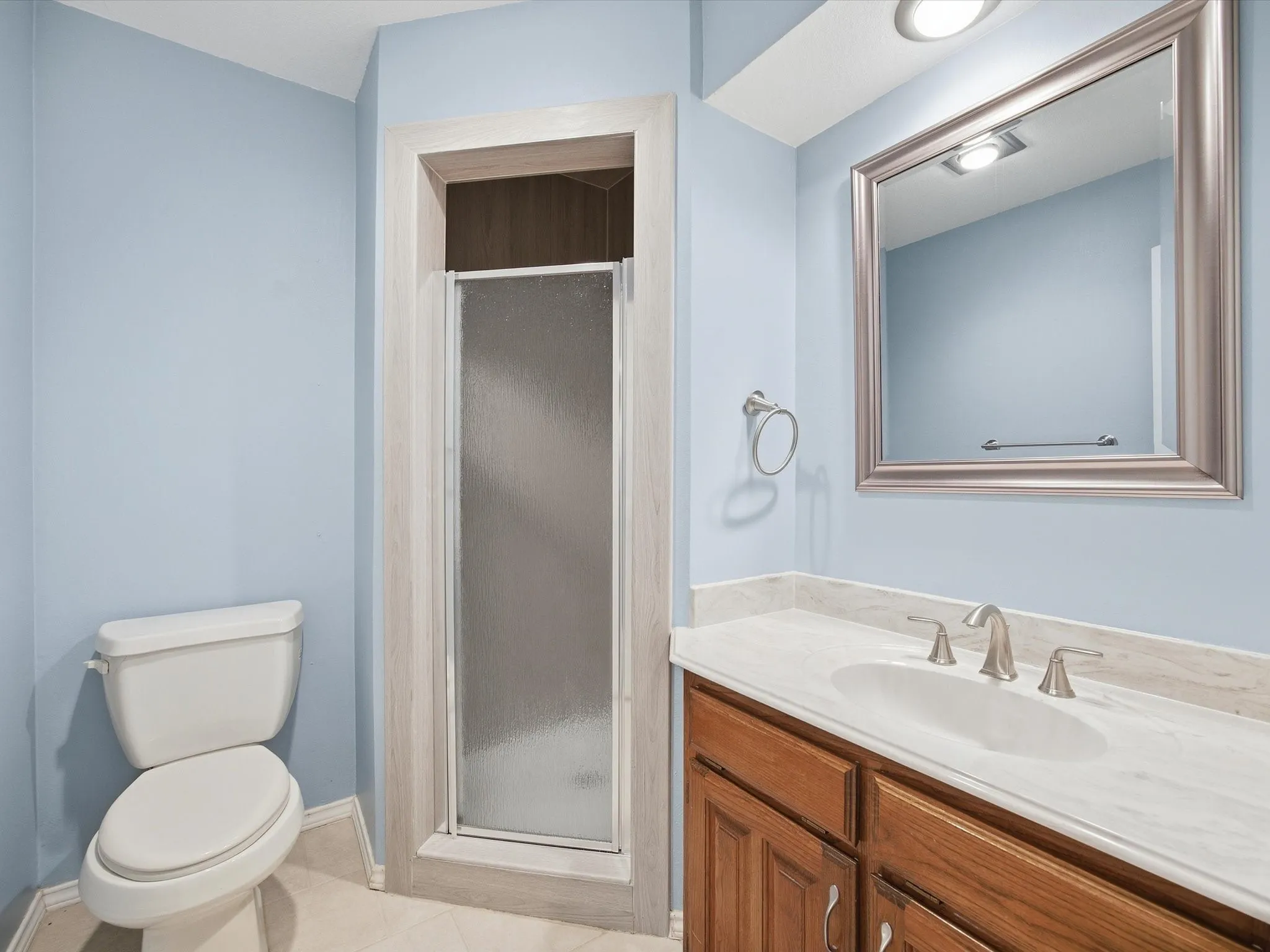 Full bath featuring a shower stall, vanity, and light tile patterned floors