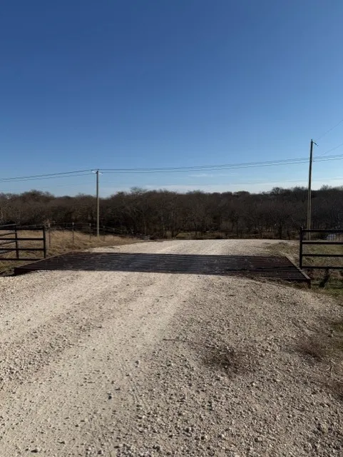 Gate near front of neighborhood entrance with cattle guard