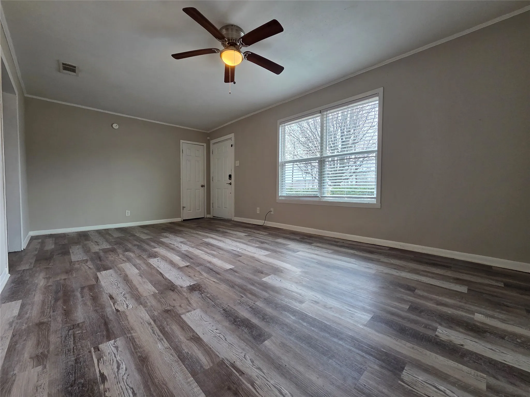 Unfurnished room featuring ornamental molding, wood finished floors, and a ceiling fan