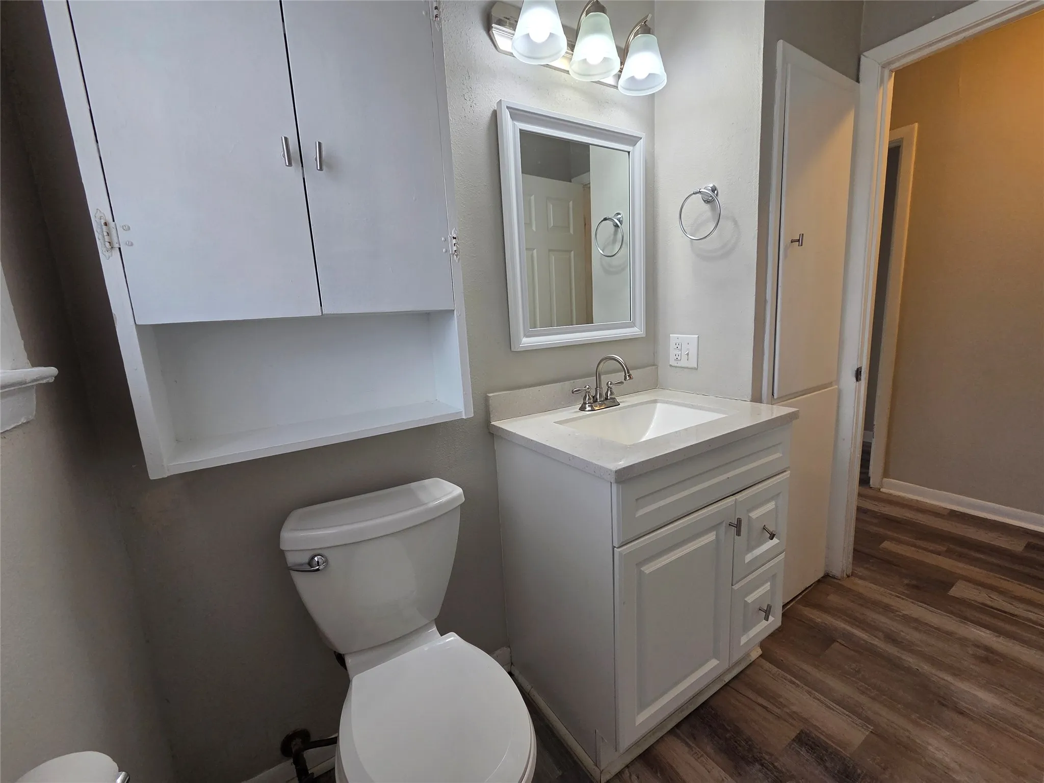 Half bath featuring vanity and dark wood finished floors