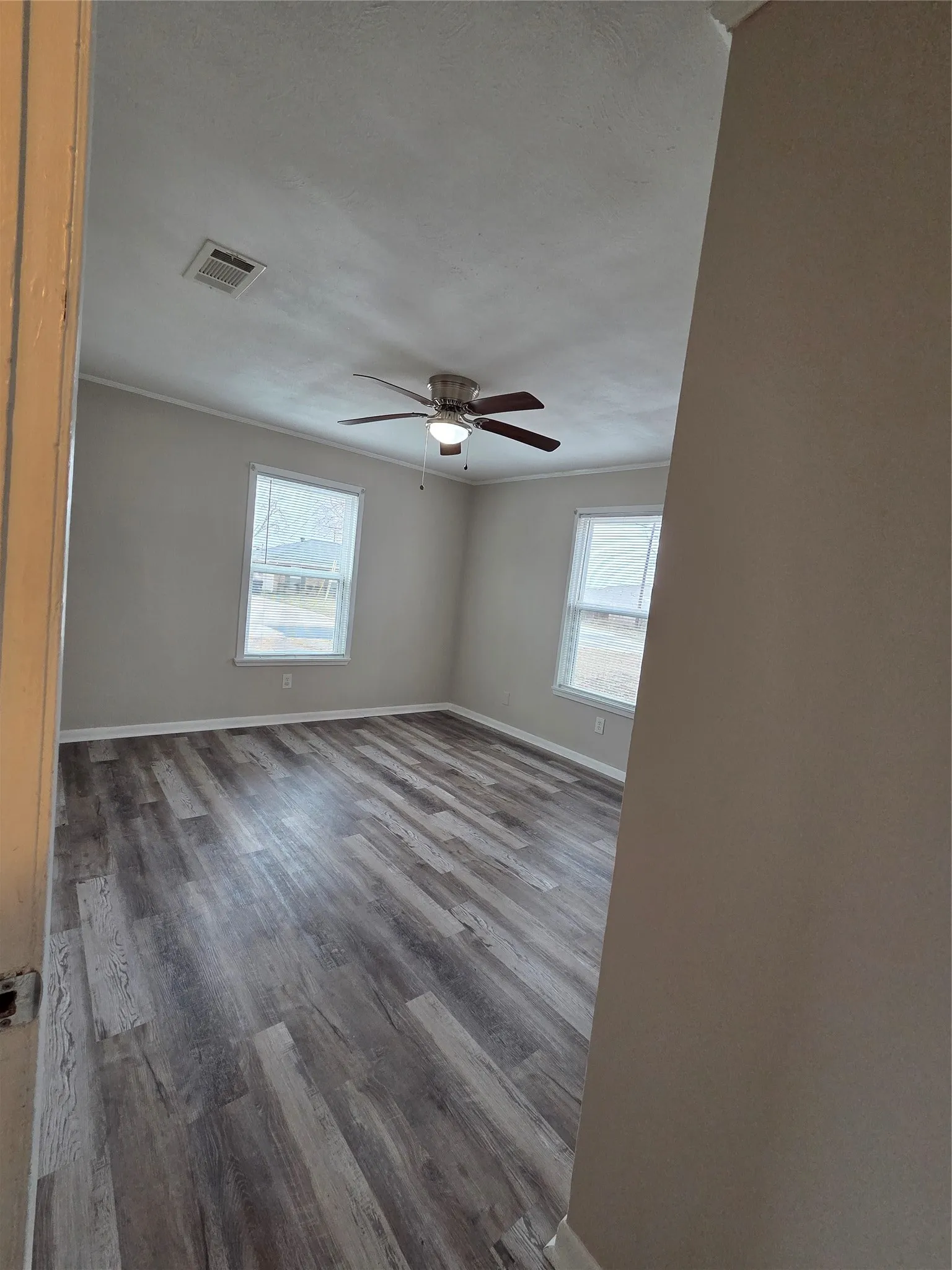 Spare room featuring dark wood-type flooring and a ceiling fan