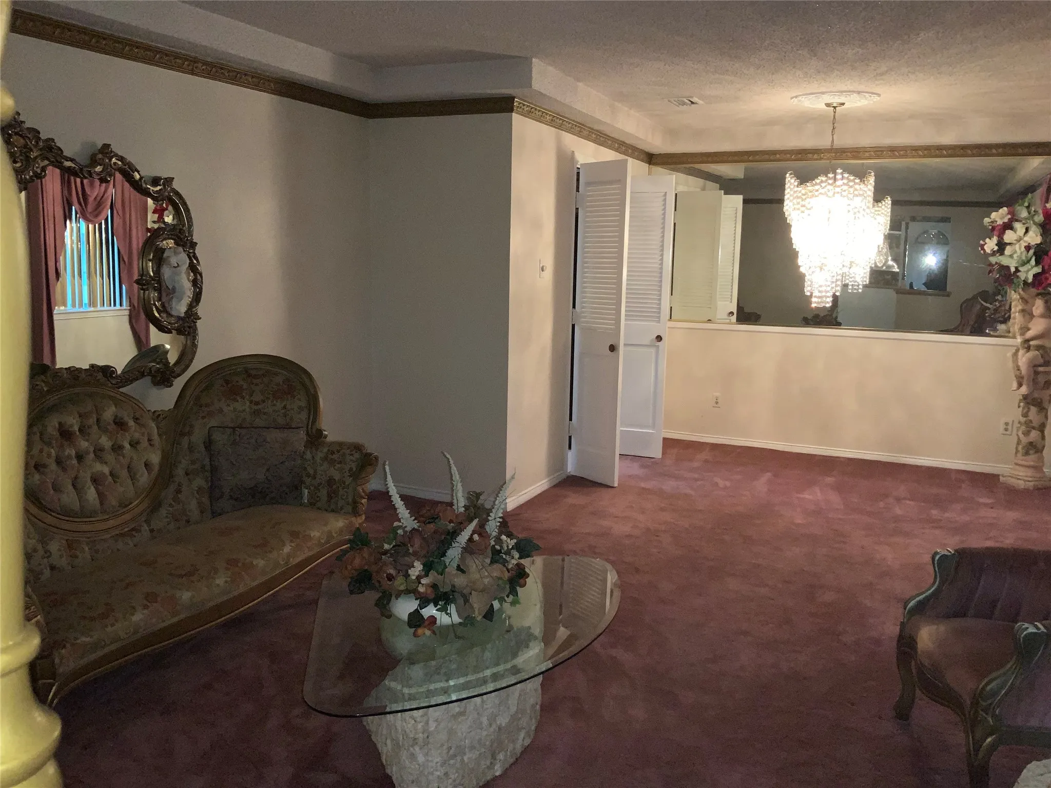Wall-to-wall carpeting with decorative crown molding and an ornate ceiling medallion