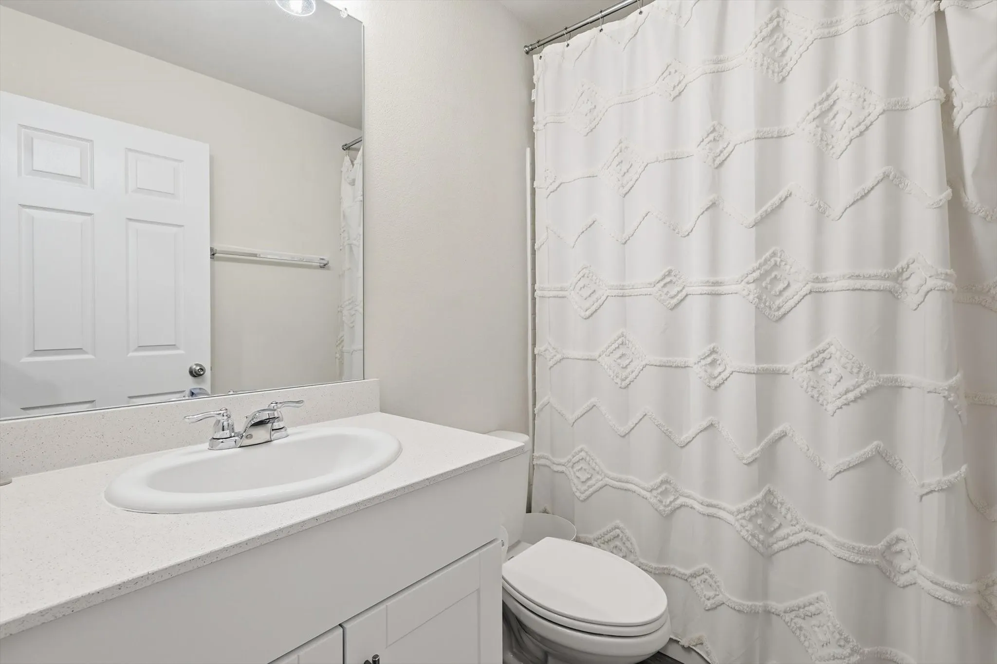 Bathroom featuring a shower with shower curtain and vanity
