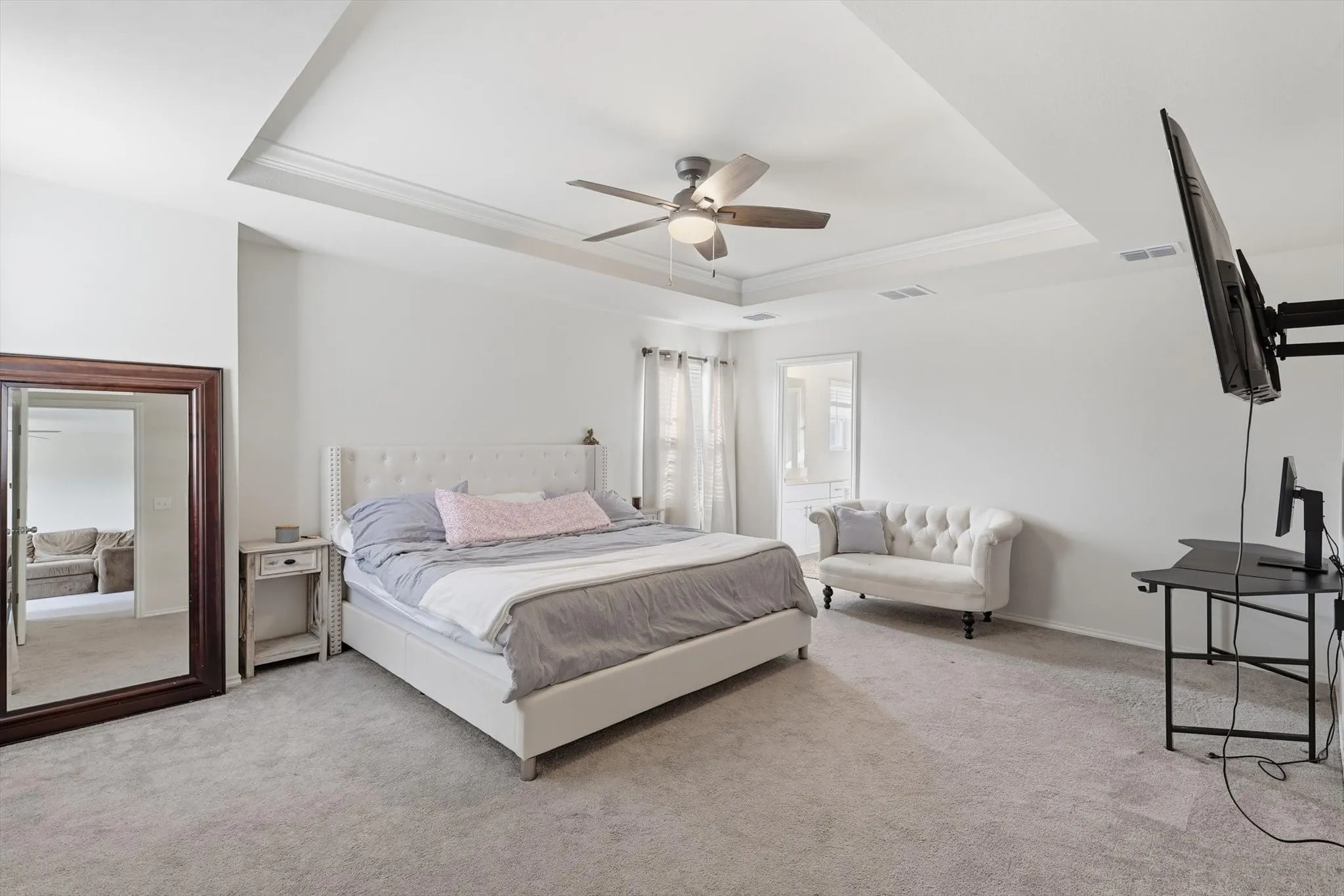 Bedroom with a raise inset ceiling, carpet, ceiling fan