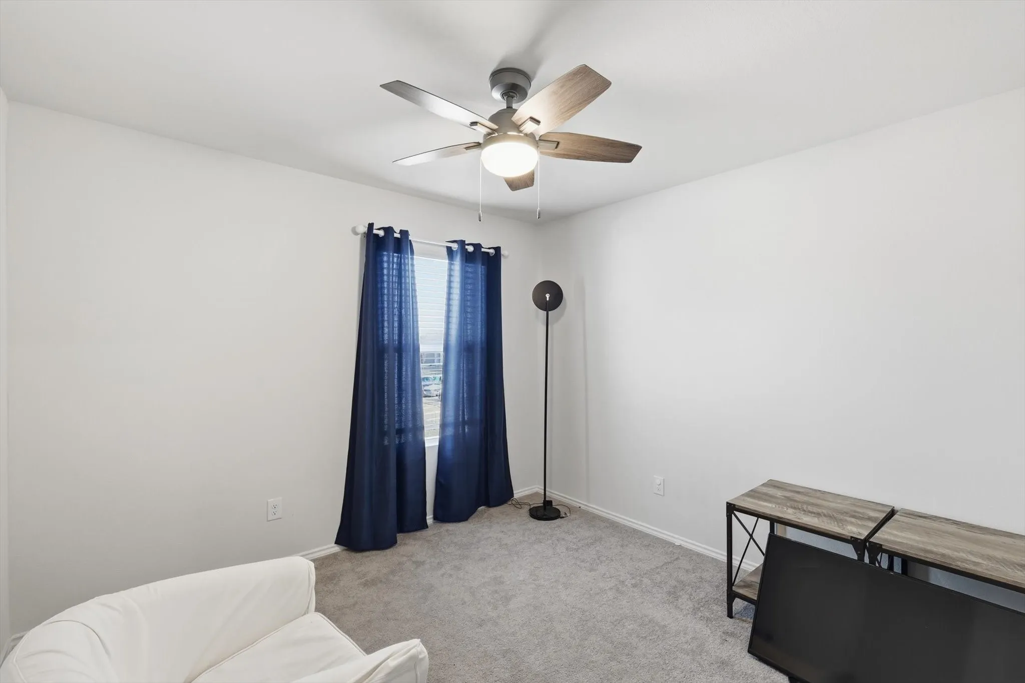 Sitting room featuring light colored carpet and a ceiling fan