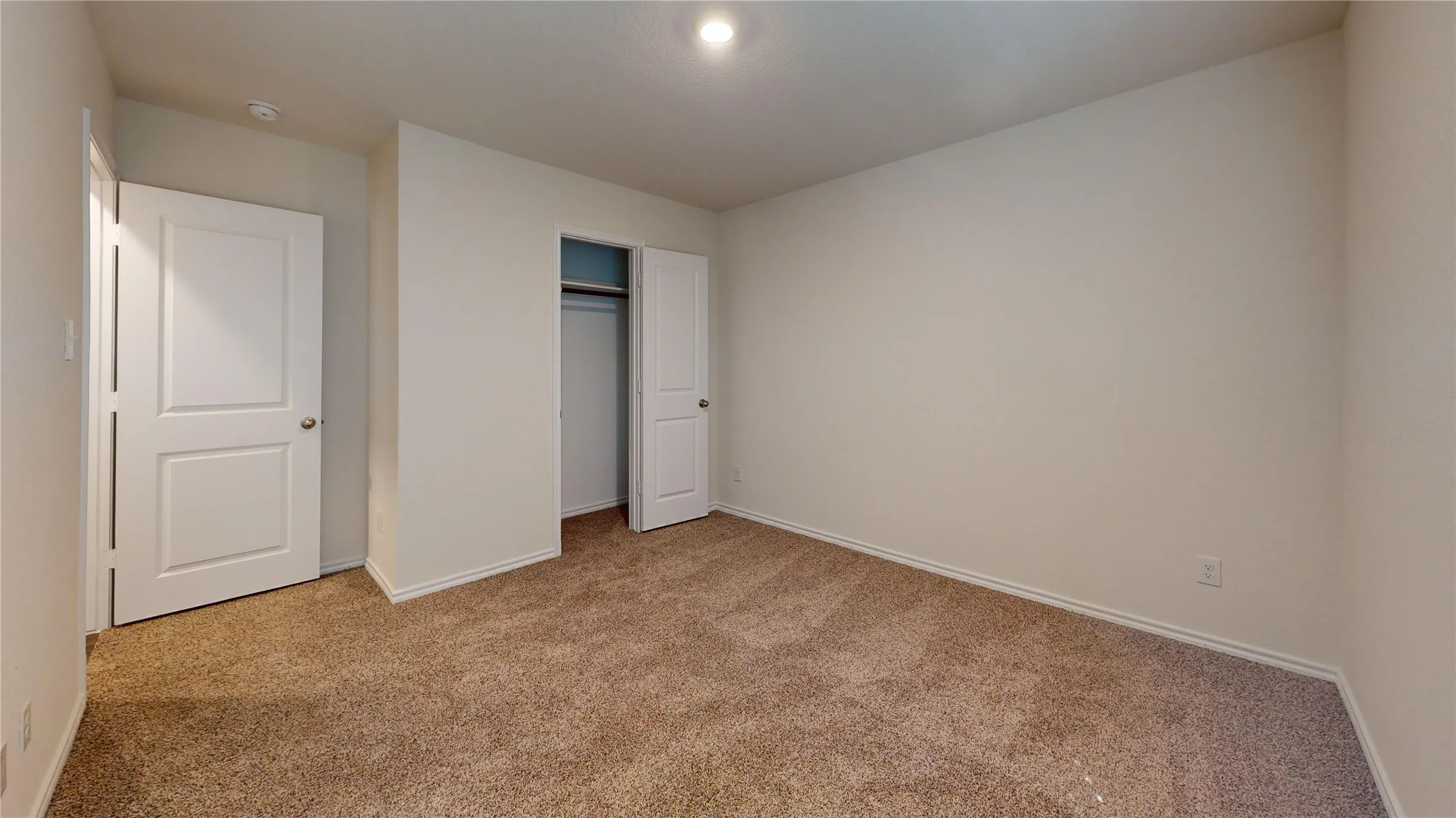 Unfurnished bedroom with light carpet and a closet