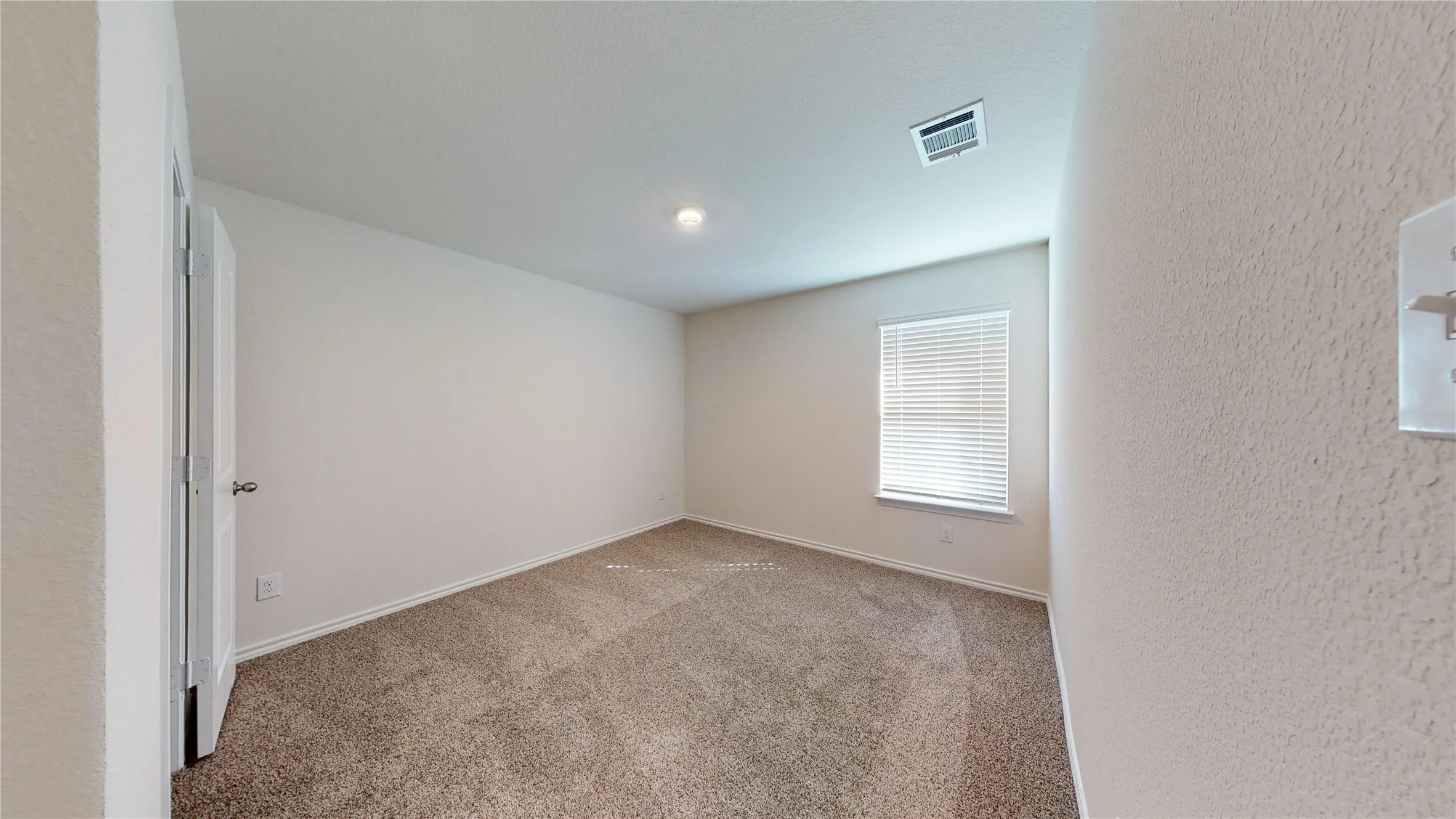 Carpeted empty room with baseboards and a textured wall