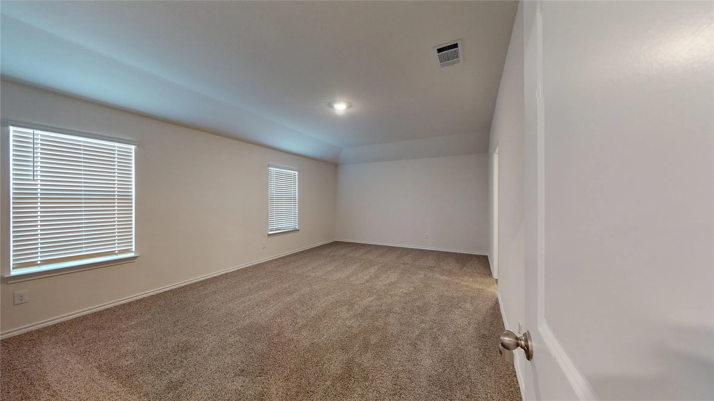 Spare room featuring light colored carpet and baseboards