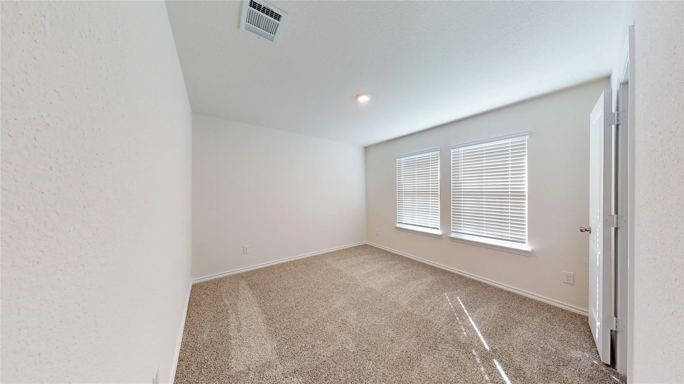 Carpeted empty room featuring baseboards