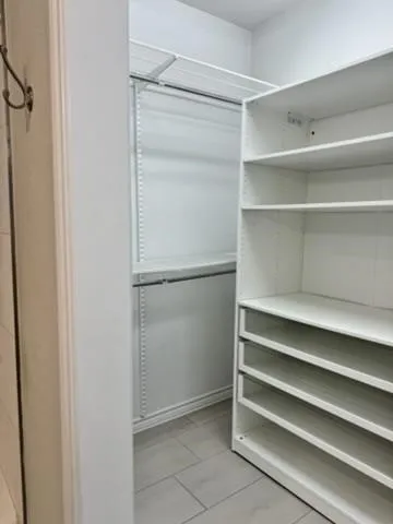Spacious closet with light tile patterned floors
