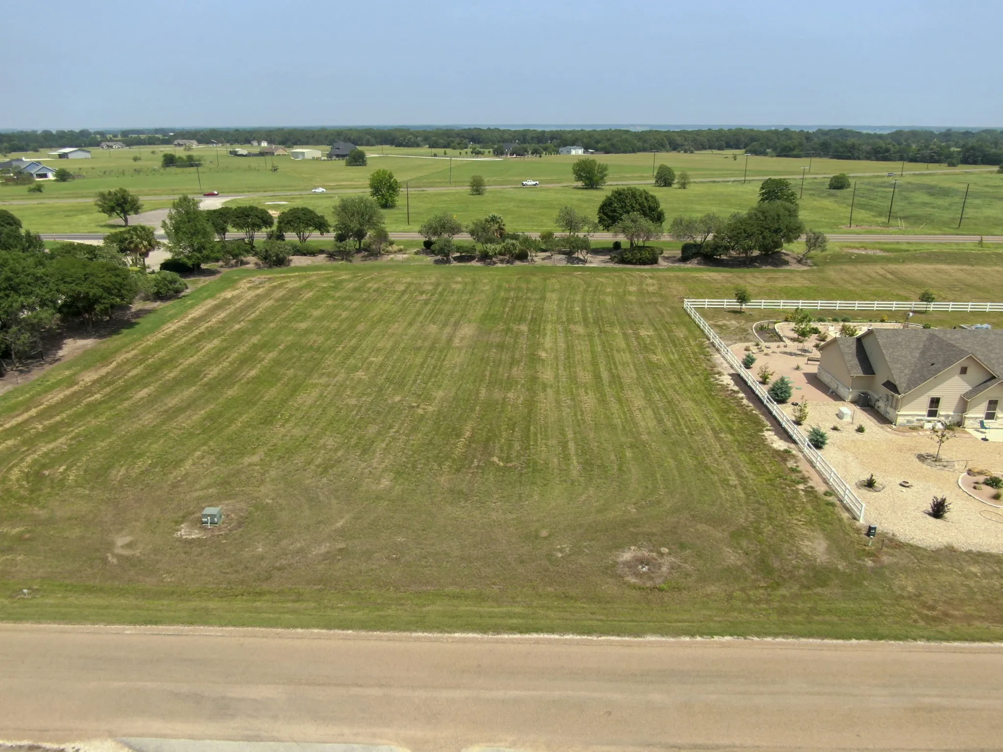 Expansive grass lot bordered by a paved road