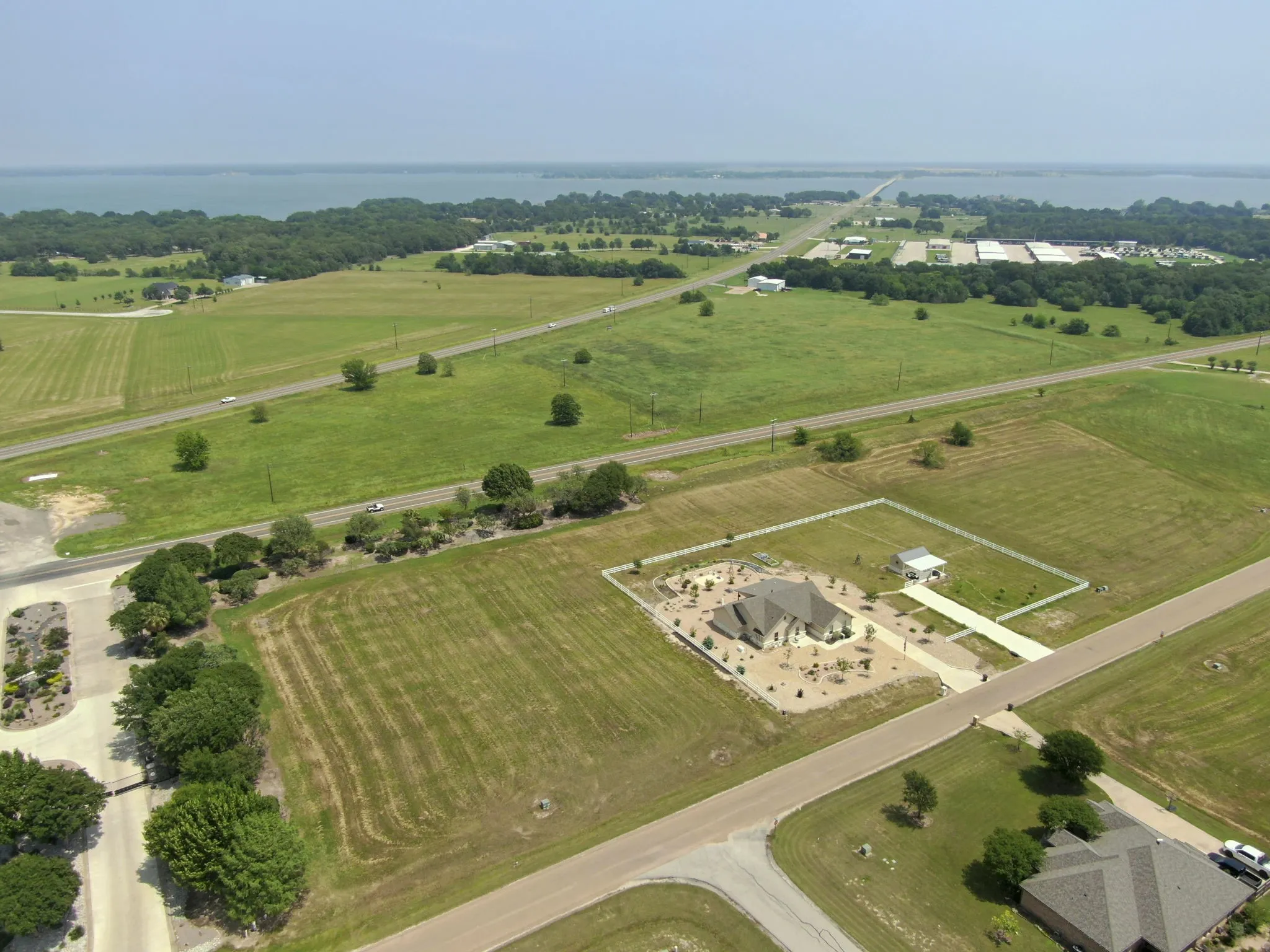 Expansive property featuring a single-story residence, detached garage, extensive landscaping, and a fenced perimeter
