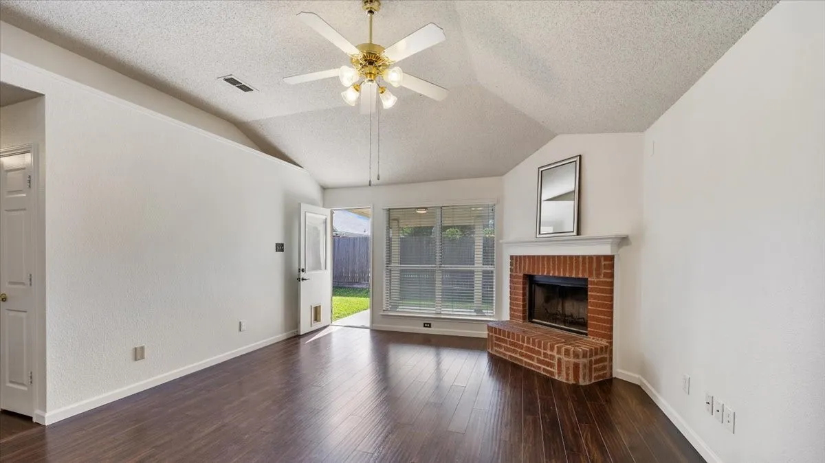 Family room with wood-burning fireplace and door to backyard.