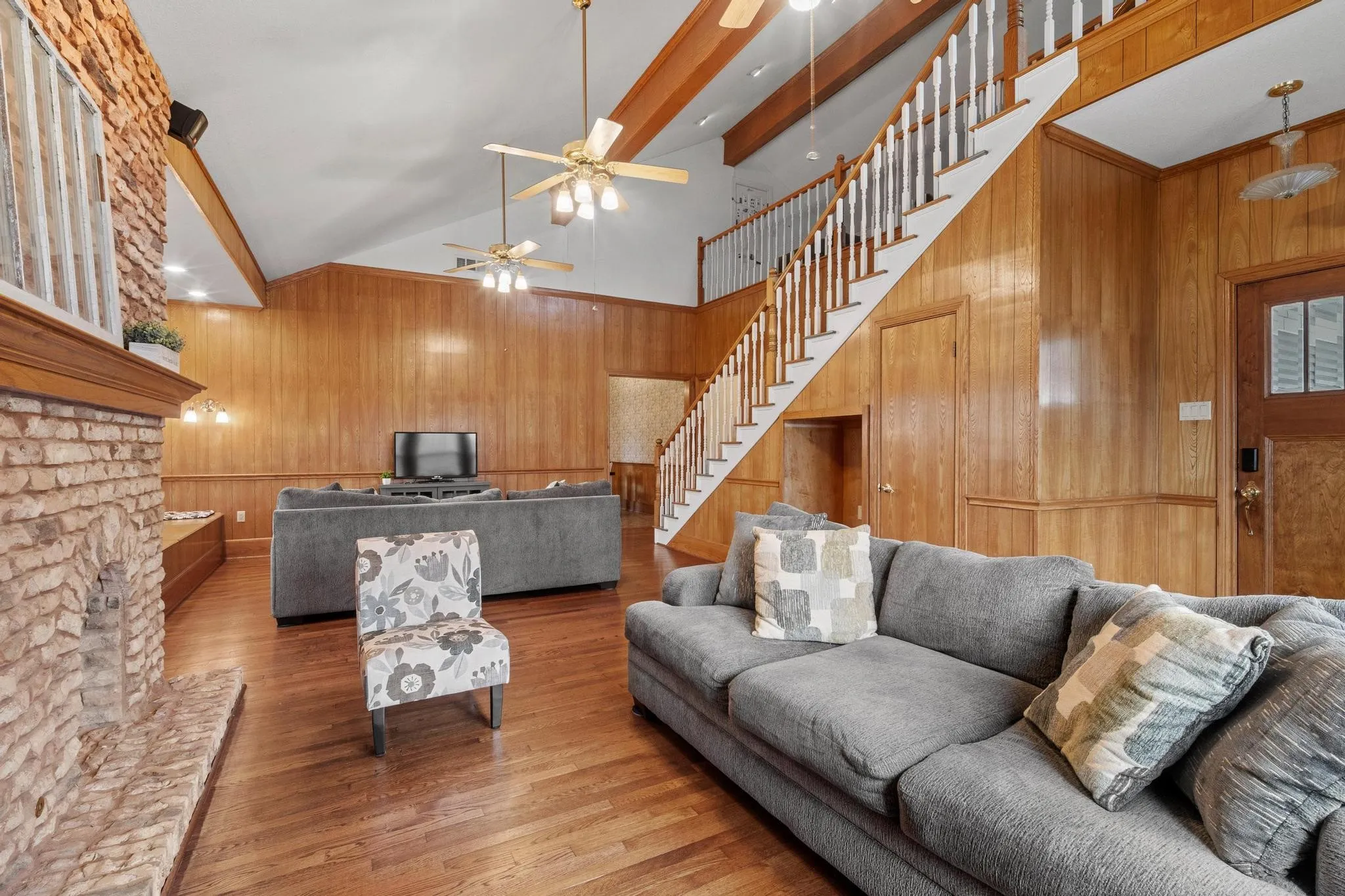 Warm wood paneling and large brick fireplace create an inviting space