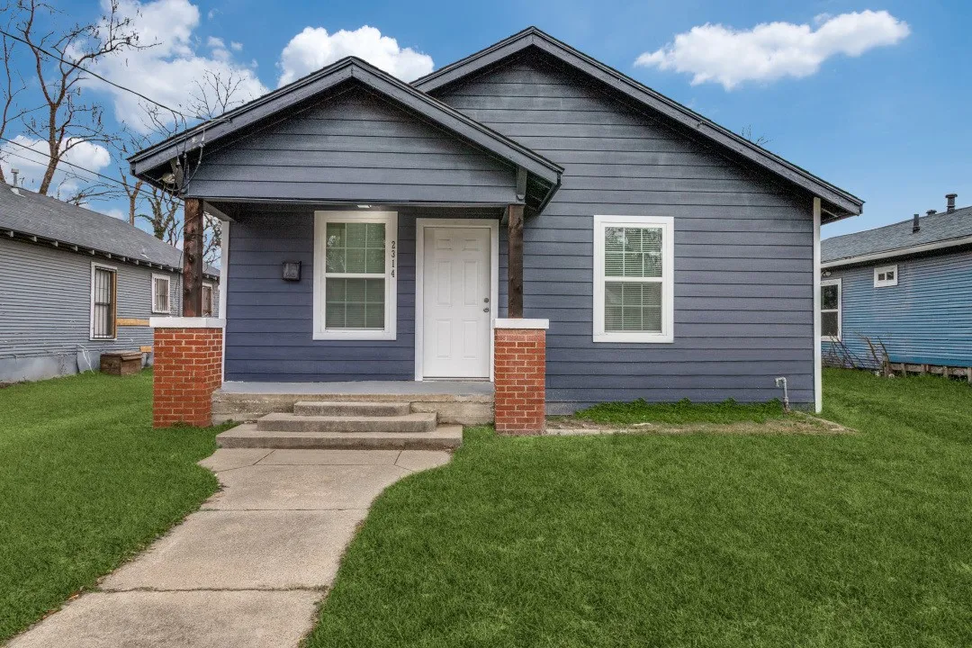View of front facade with covered porch and a front yard