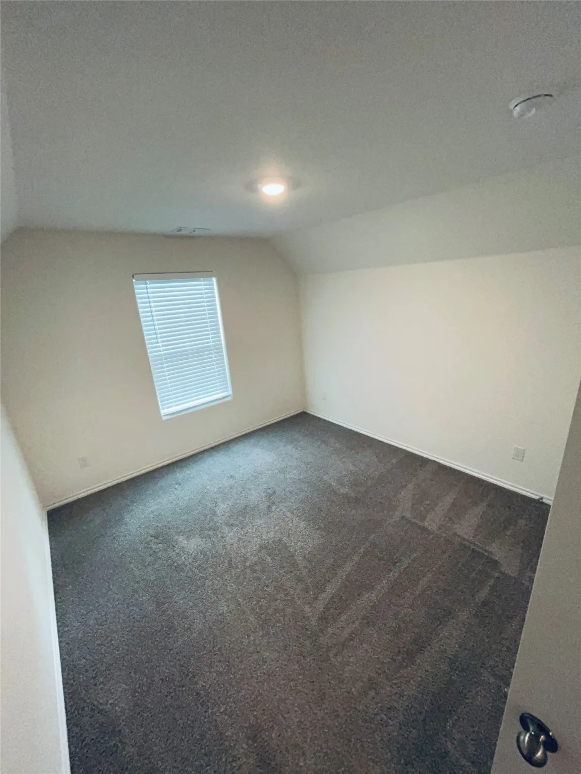 Bedroom 1 with vaulted ceiling, carpet, and a textured ceiling