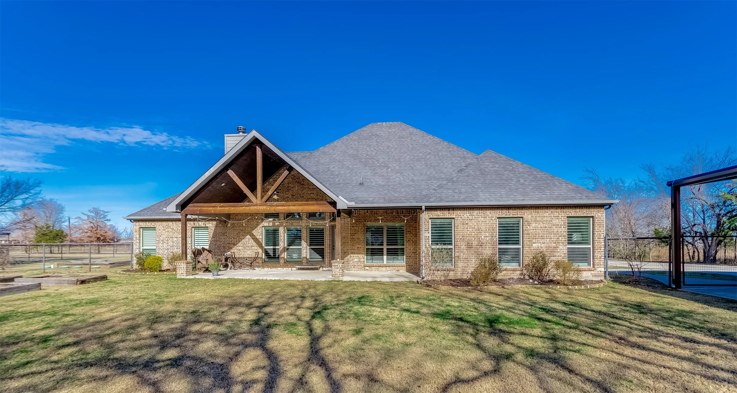 Back of house with a patio, brick siding, and a chimney