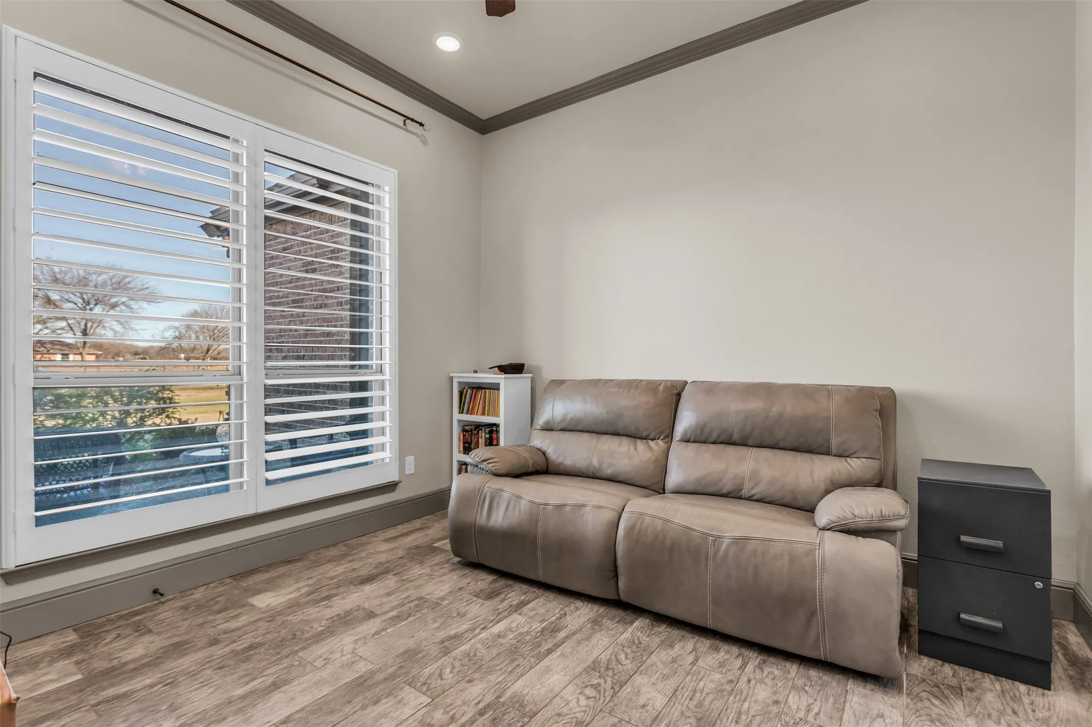 Sitting room with ornamental molding, light wood-type flooring, and recessed lighting