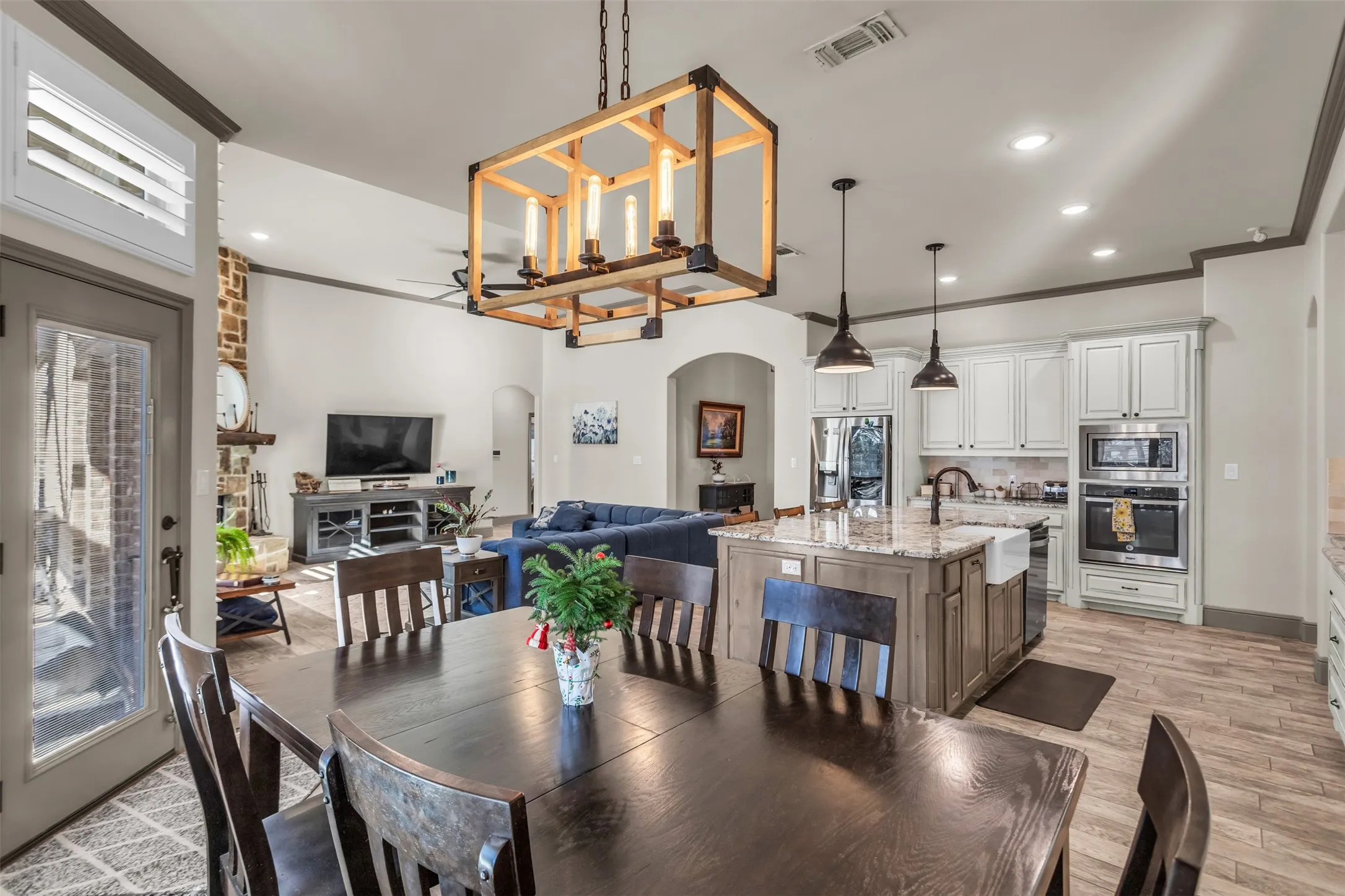 Dining space featuring arched walkways, ornamental molding, recessed lighting, light wood-style flooring, and healthy amount of natural light