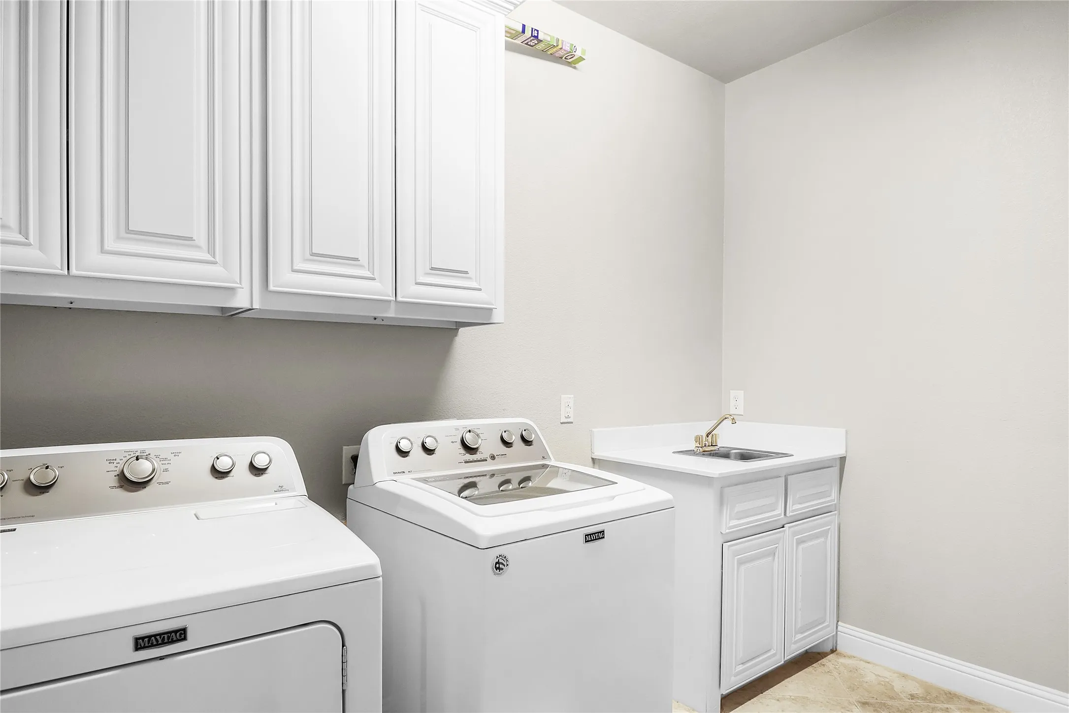 laundry room with sink and cabinets.