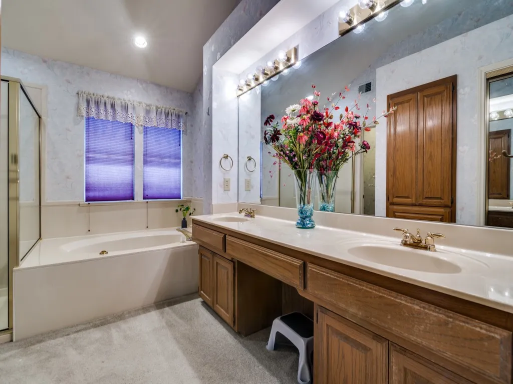 Full bath with a garden tub, double vanity, and wallpapered walls