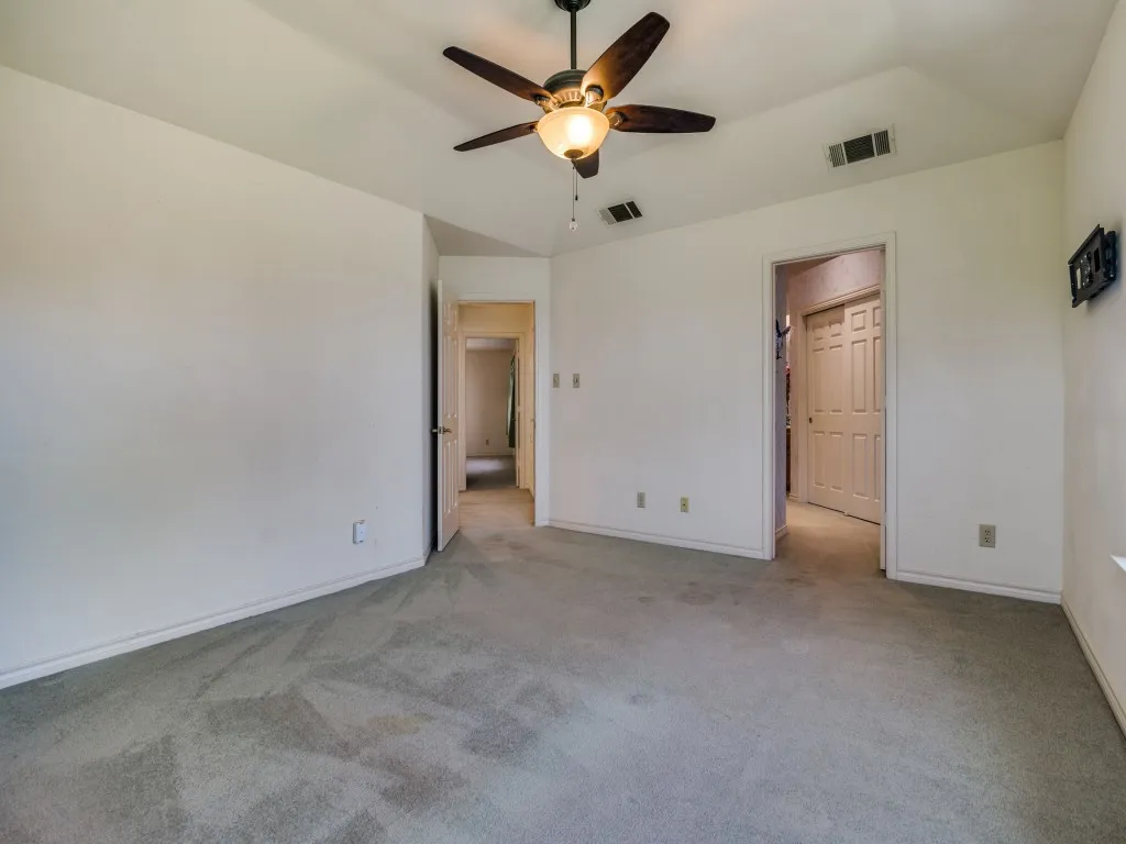 Unfurnished bedroom featuring light carpet and a ceiling fan