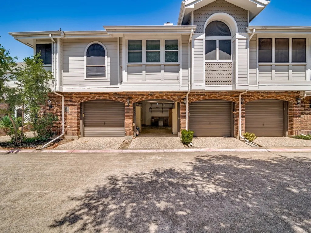 View of front of property featuring an attached garage and brick siding