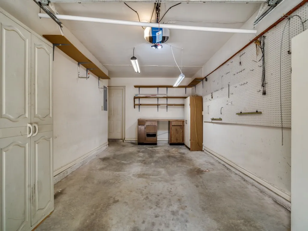 Garage featuring a garage door opener and baseboards