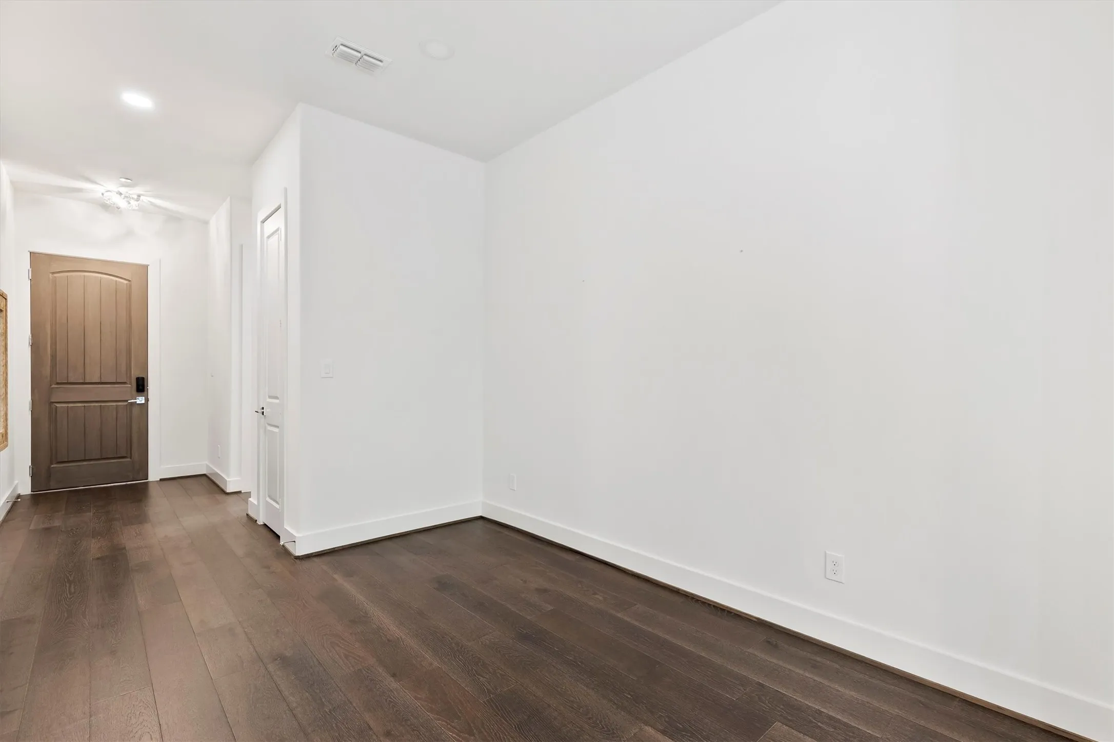 Unfurnished room with dark wood flooring and recessed lighting