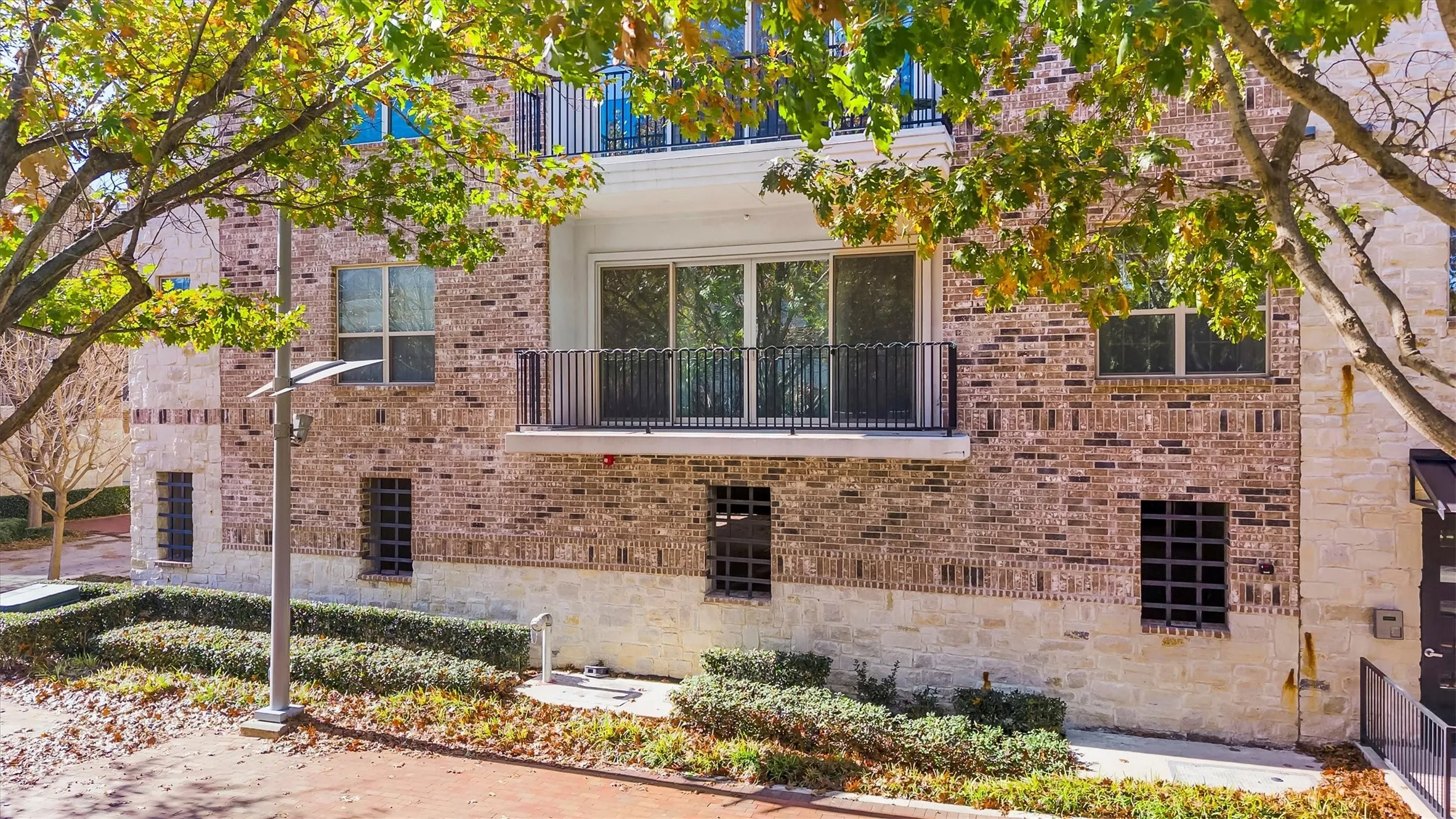 View of side of home with a balcony and brick siding
